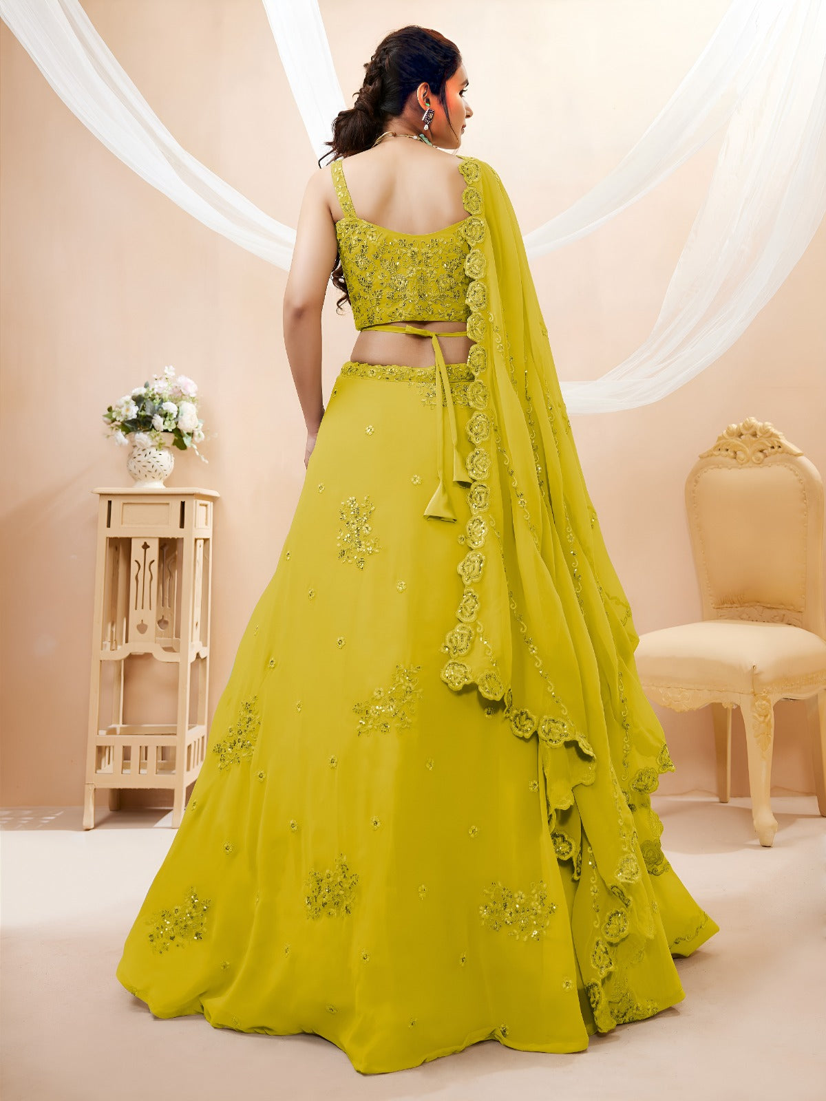 Model wearing a stunning lime green designer lehenga choli featuring intricate embroidery and a matching sheer dupatta