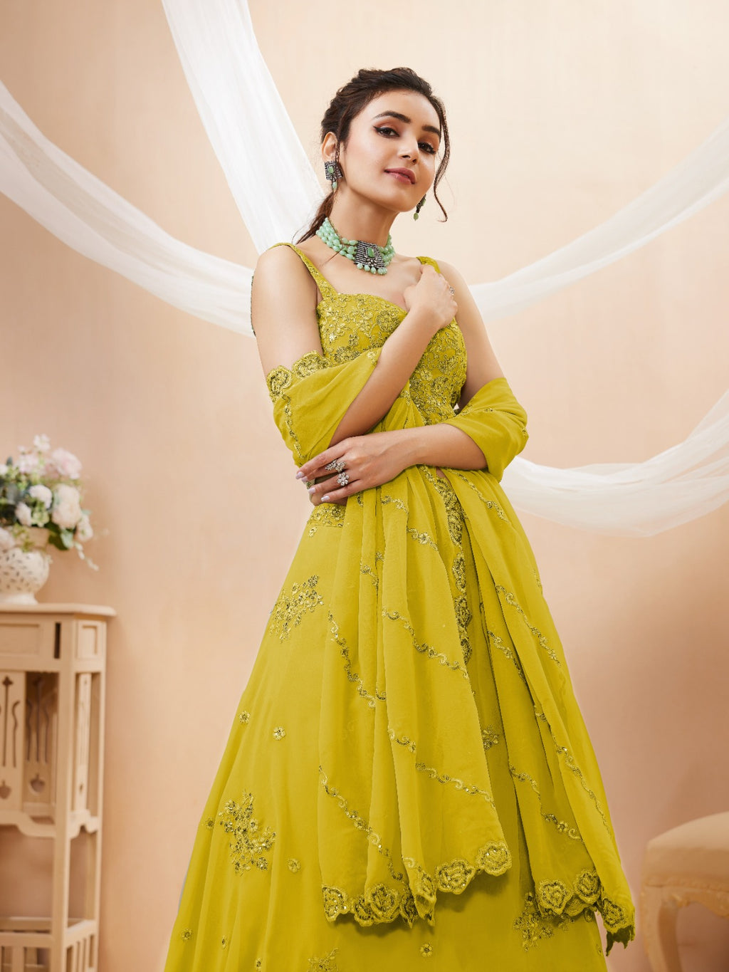 Model wearing a stunning lime green designer lehenga choli featuring intricate embroidery and a matching sheer dupatta