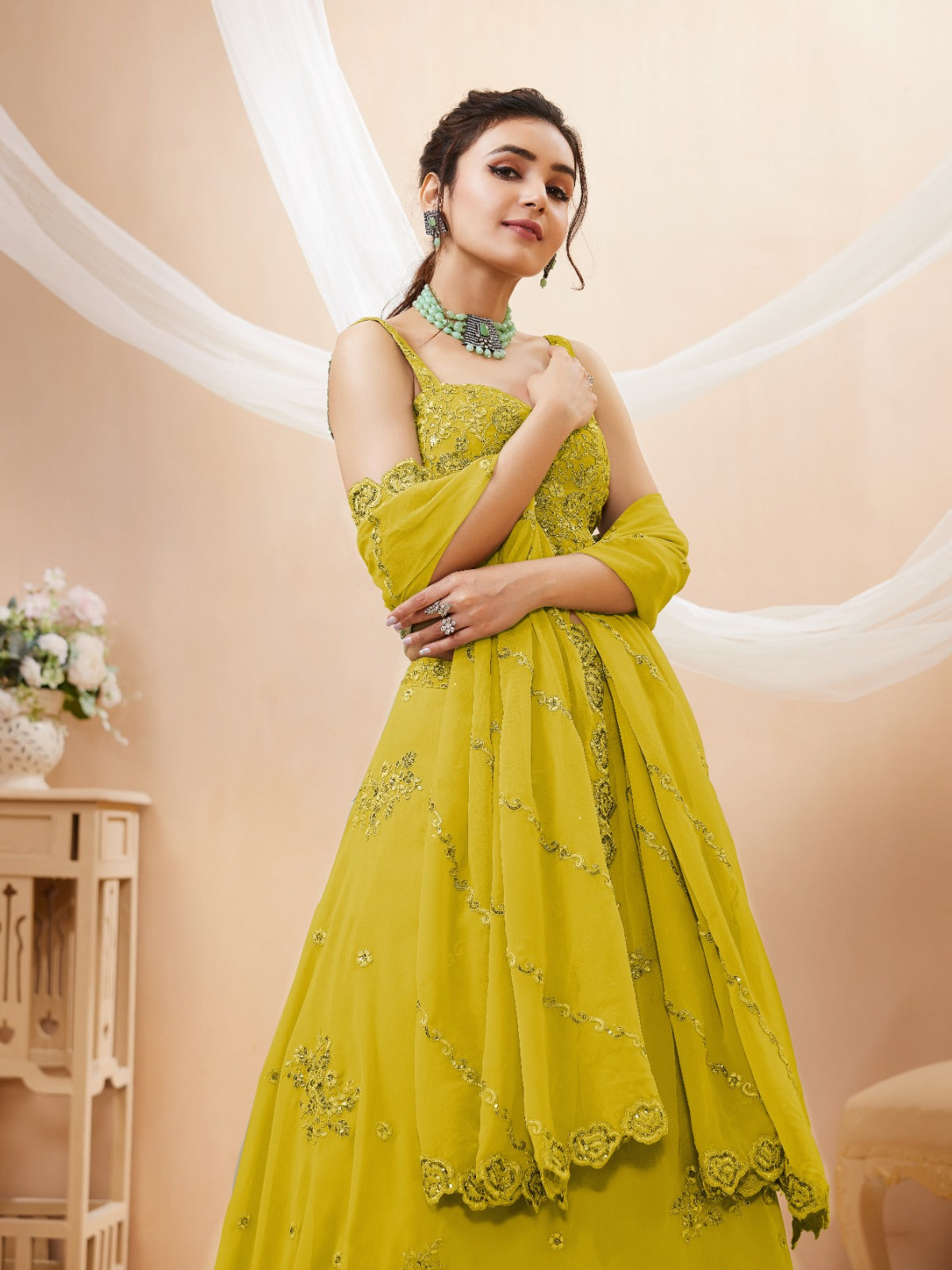 Model wearing a stunning lime green designer lehenga choli featuring intricate embroidery and a matching sheer dupatta