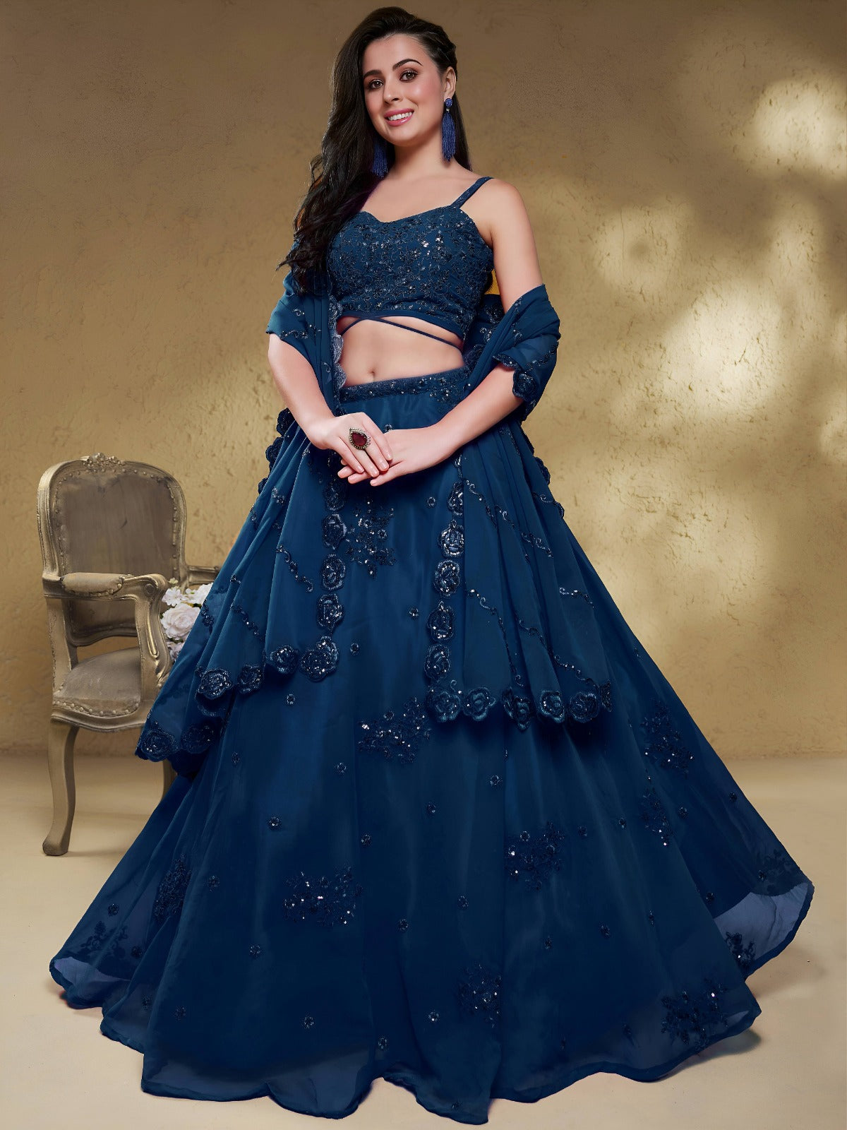Model wearing a stunning navy blue designer lehenga choli featuring intricate embroidery and a matching sheer dupatta