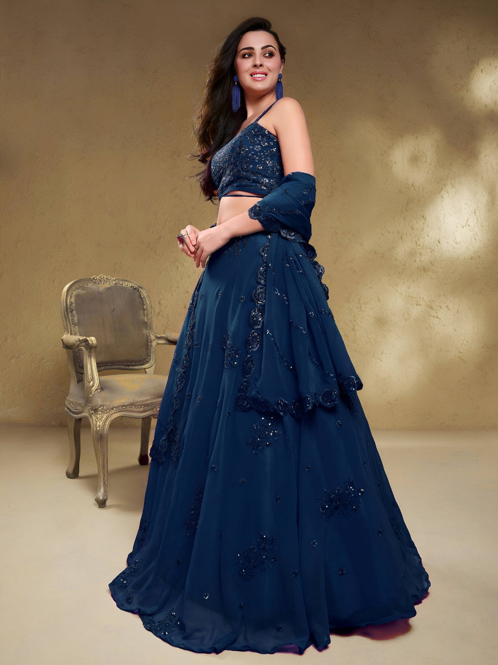 Model wearing a stunning navy blue designer lehenga choli featuring intricate embroidery and a matching sheer dupatta