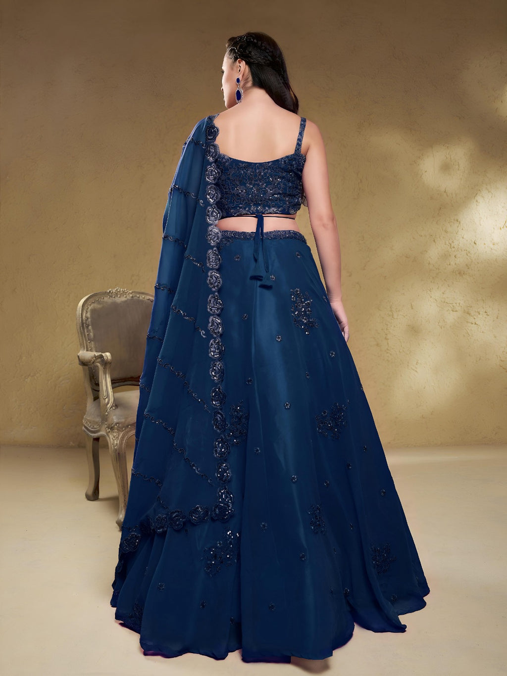Model wearing a stunning navy blue designer lehenga choli featuring intricate embroidery and a matching sheer dupatta