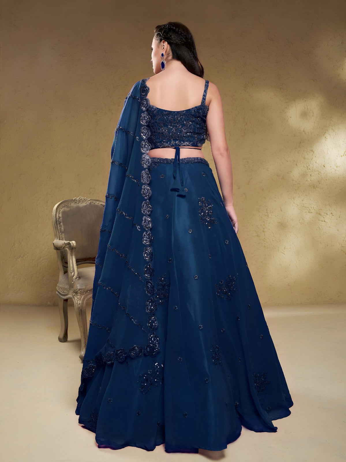 Model wearing a stunning navy blue designer lehenga choli featuring intricate embroidery and a matching sheer dupatta