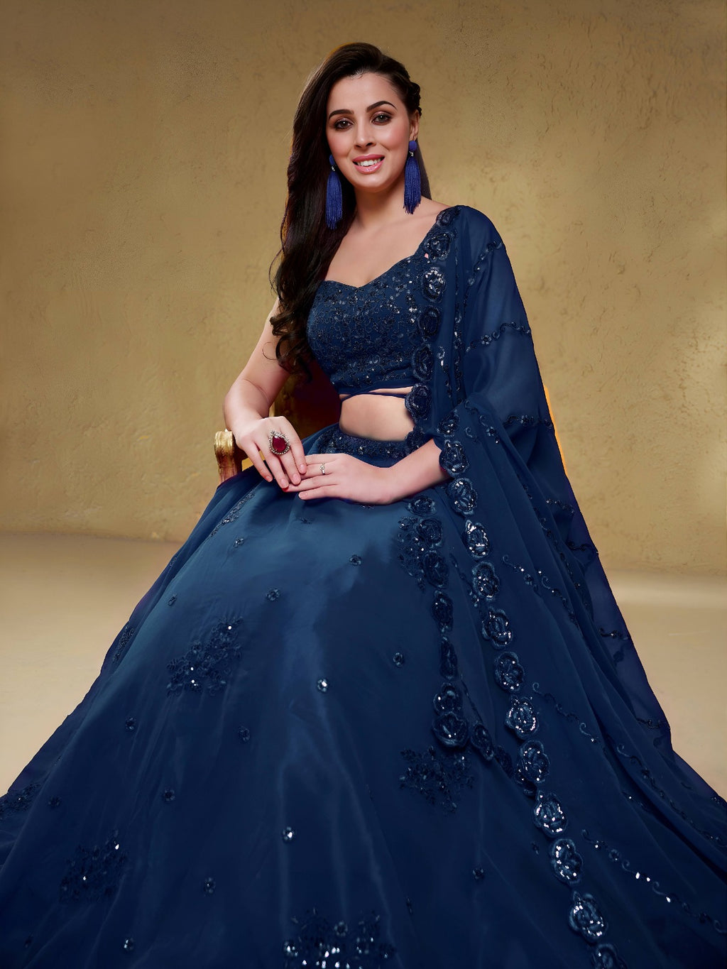 Model wearing a stunning navy blue designer lehenga choli featuring intricate embroidery and a matching sheer dupatta