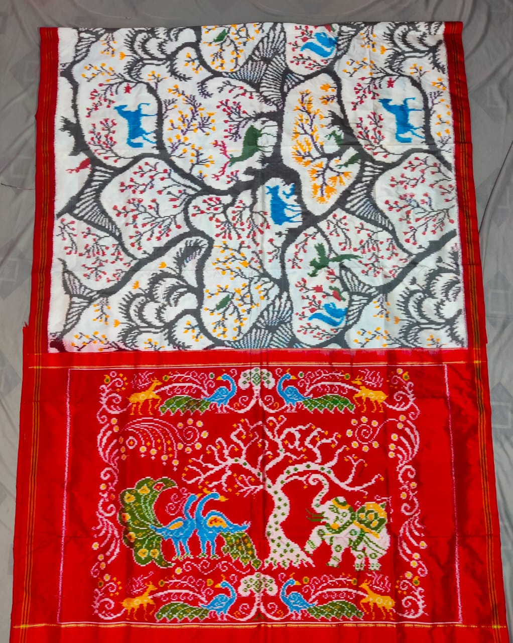 Red Pochampally Handloom Ikat Madthasu Patola Silk Saree featuring traditional double warp Ikat motifs, figurative panels, and a rich red pallu.