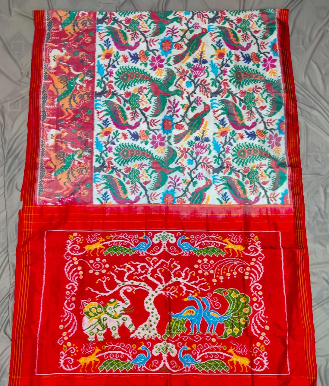 Red Pochampally Handloom Ikat Madthasu Patola Silk Saree featuring traditional double warp Ikat motifs, figurative panels, and a rich red pallu.