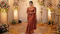 A south Indian bride wearing Copper Kanchipuram Handloom Tissue Brocade Silk Meenakari Saree showcasing its rich gold zari and floral weave details.