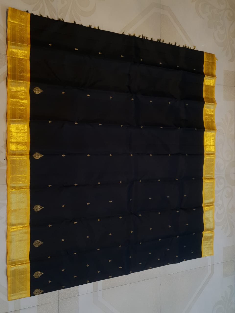 A luxurious black Kanchipuram handloom 4G pure gold pattu silk saree featuring intricate traditional motifs and a lustrous weave.