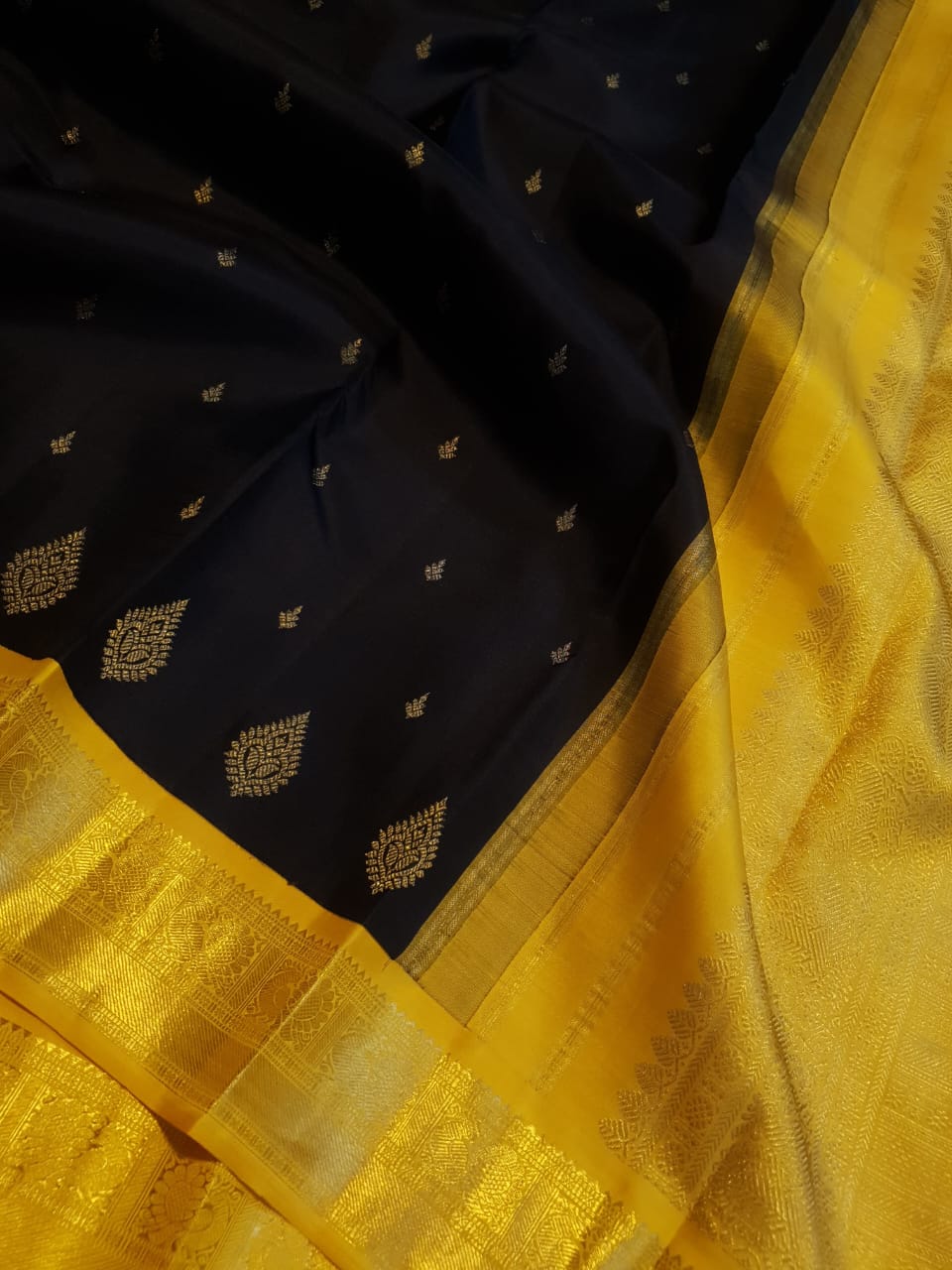 A luxurious black Kanchipuram handloom 4G pure gold pattu silk saree featuring intricate traditional motifs and a lustrous weave.
