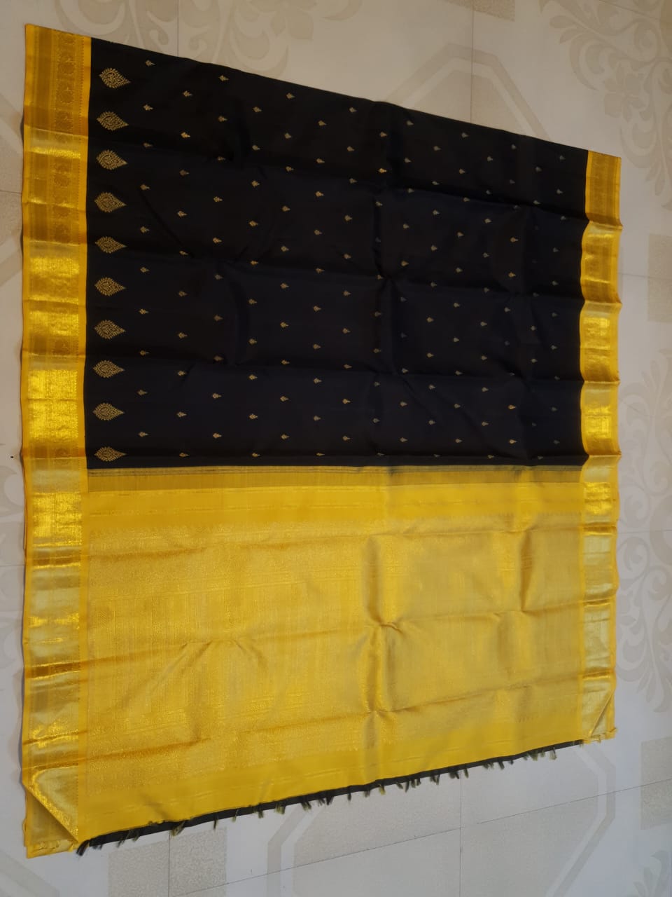 A luxurious black Kanchipuram handloom 4G pure gold pattu silk saree featuring intricate traditional motifs and a lustrous weave.