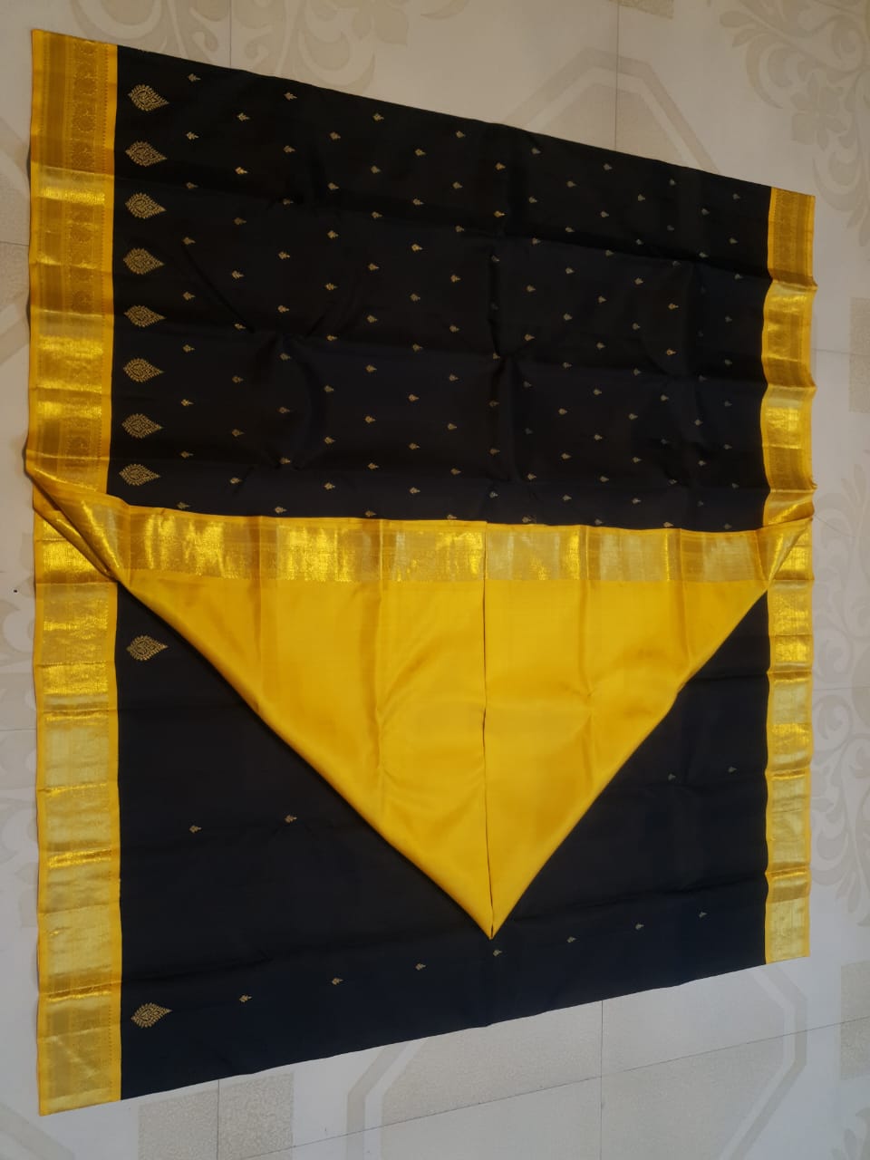 A luxurious black Kanchipuram handloom 4G pure gold pattu silk saree featuring intricate traditional motifs and a lustrous weave.