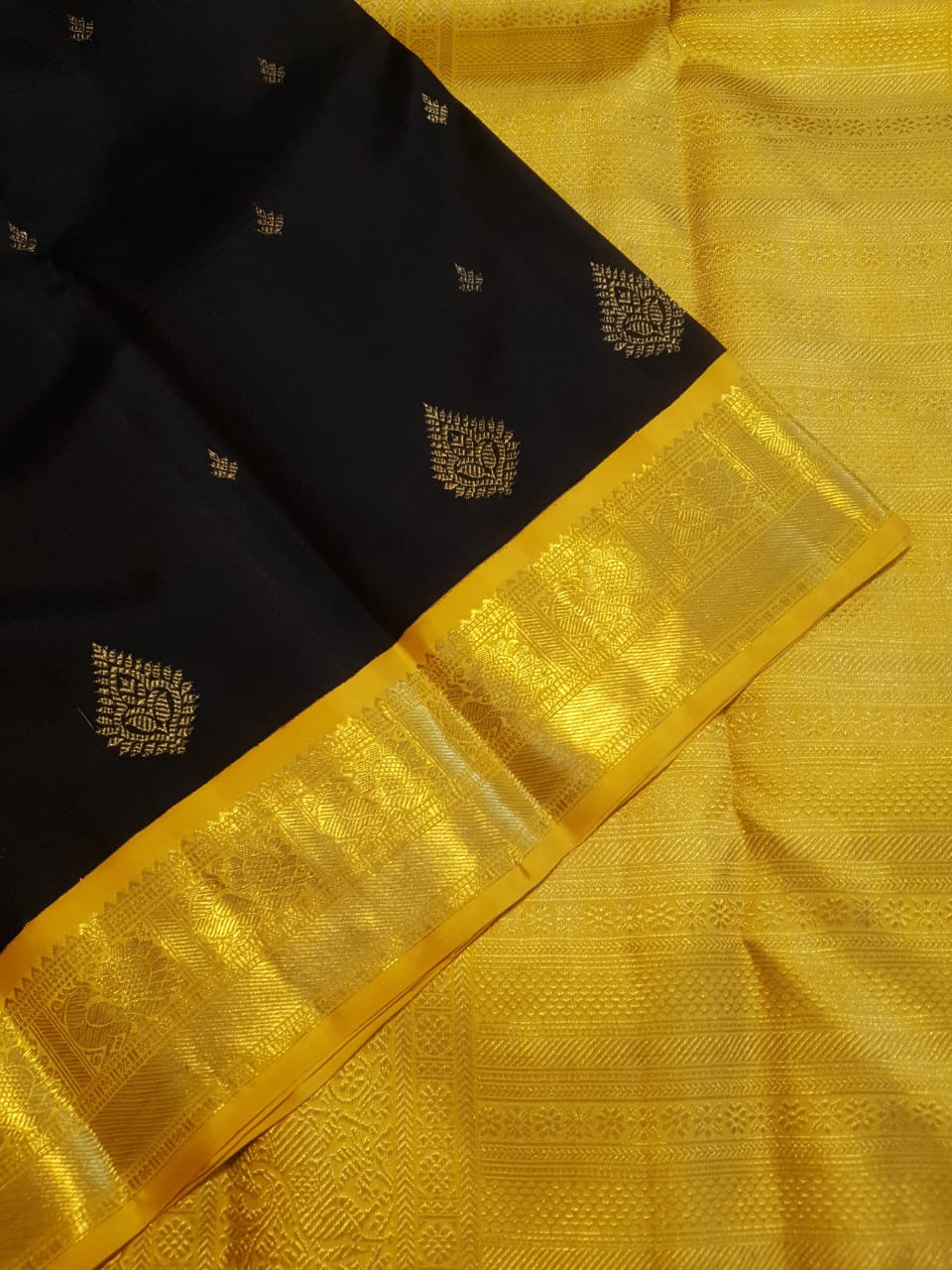 A luxurious black Kanchipuram handloom 4G pure gold pattu silk saree featuring intricate traditional motifs and a lustrous weave.