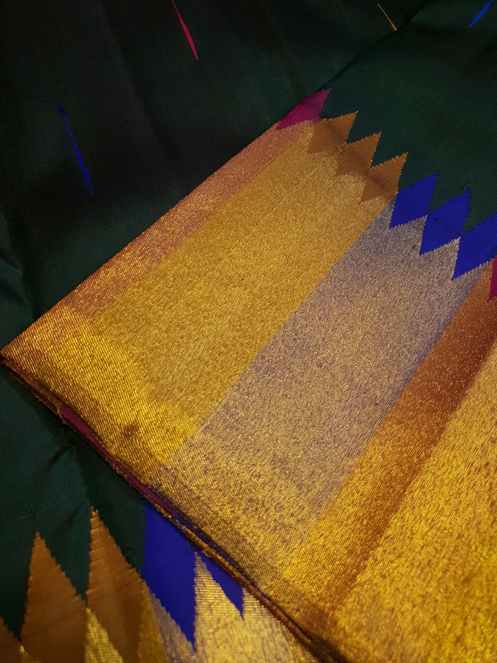 Bottle green Kanchipuram handloom 2G silk saree with 8-color temple border, traditional gold zari, and vibrant purple accents, perfect for weddings and festive occasions.
