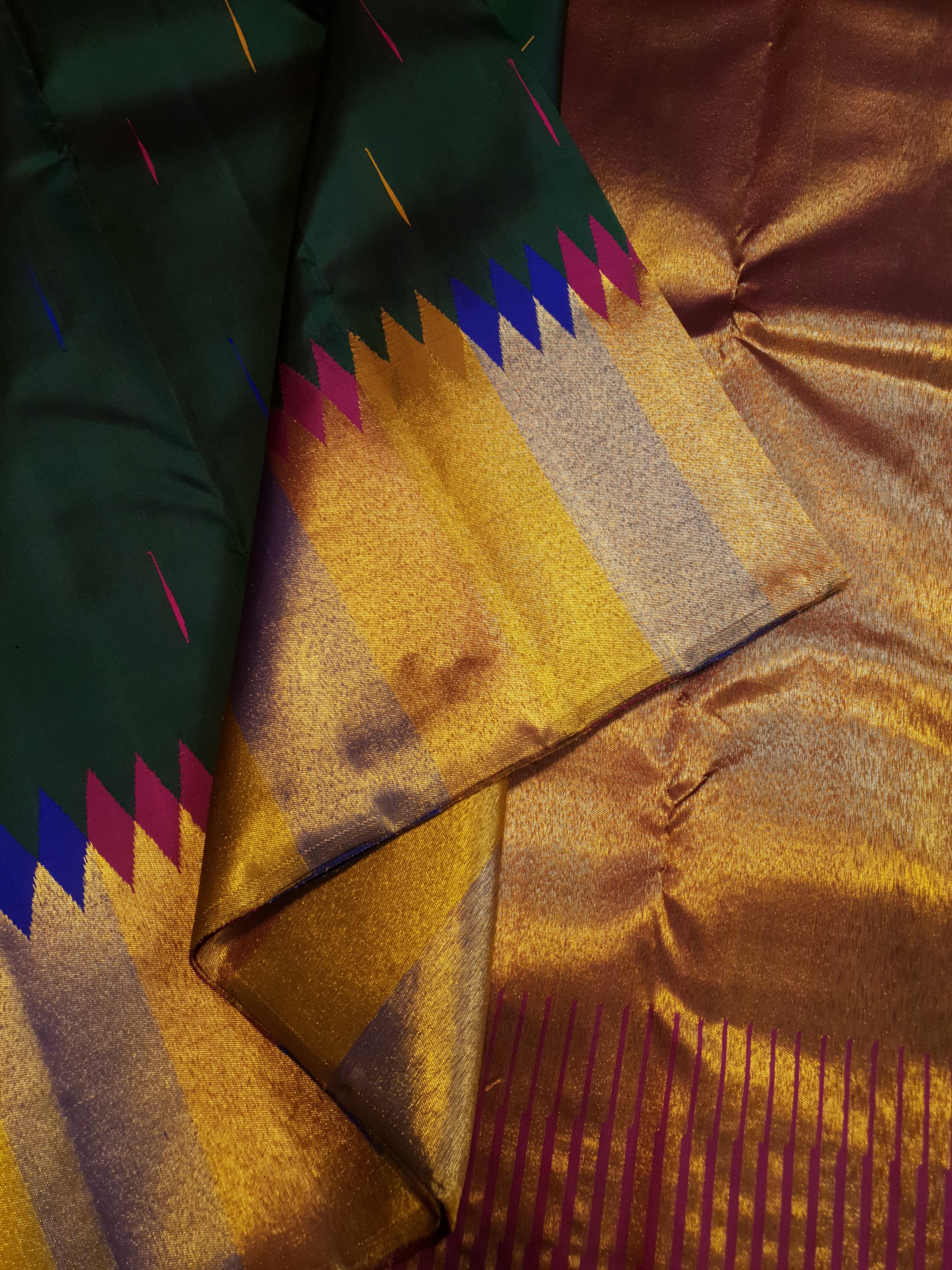 Bottle green Kanchipuram handloom 2G silk saree with 8-color temple border, traditional gold zari, and vibrant purple accents, perfect for weddings and festive occasions.