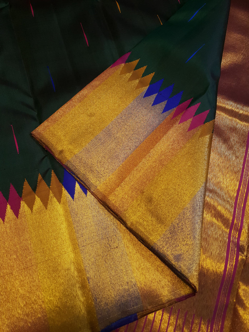 Bottle green Kanchipuram handloom 2G silk saree with 8-color temple border, traditional gold zari, and vibrant purple accents, perfect for weddings and festive occasions.