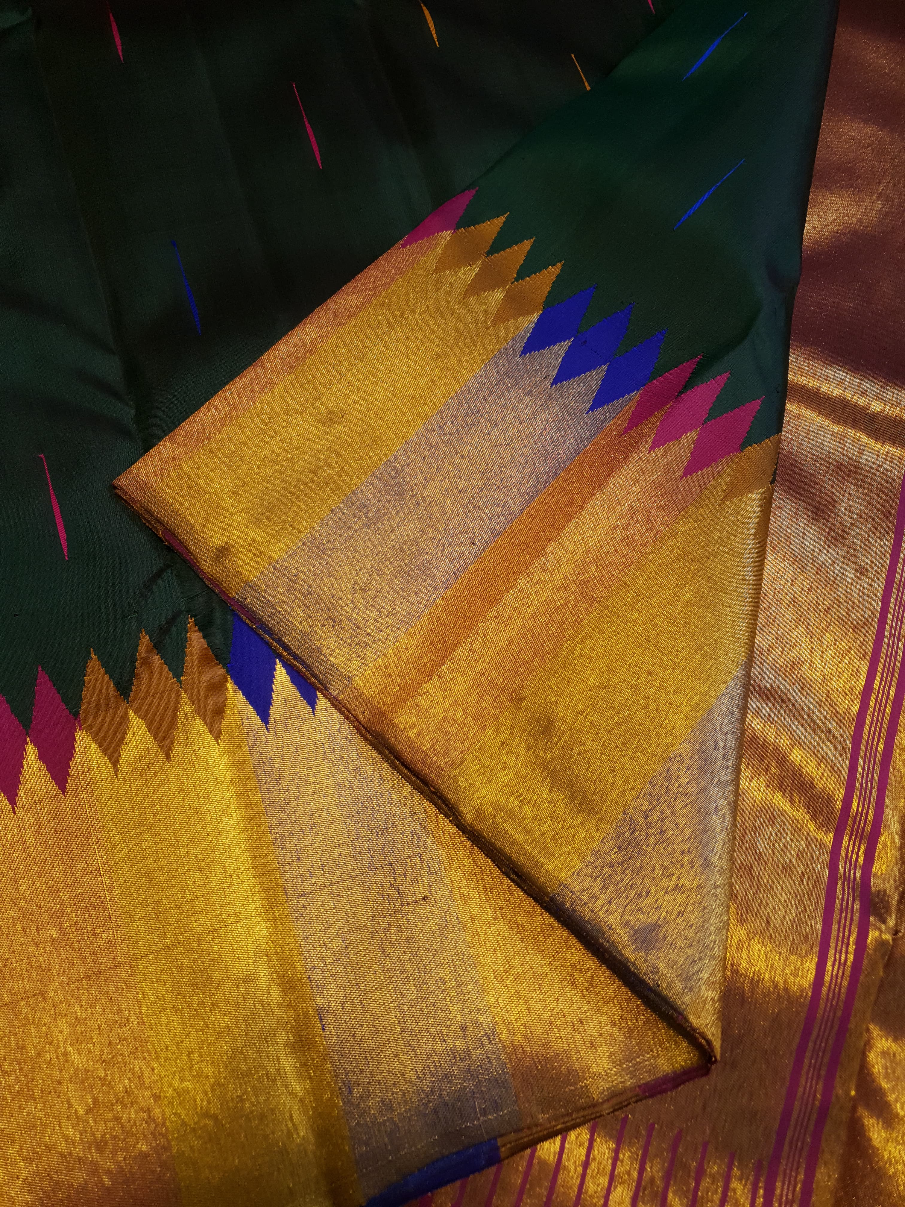 Bottle green Kanchipuram handloom 2G silk saree with 8-color temple border, traditional gold zari, and vibrant purple accents, perfect for weddings and festive occasions.
