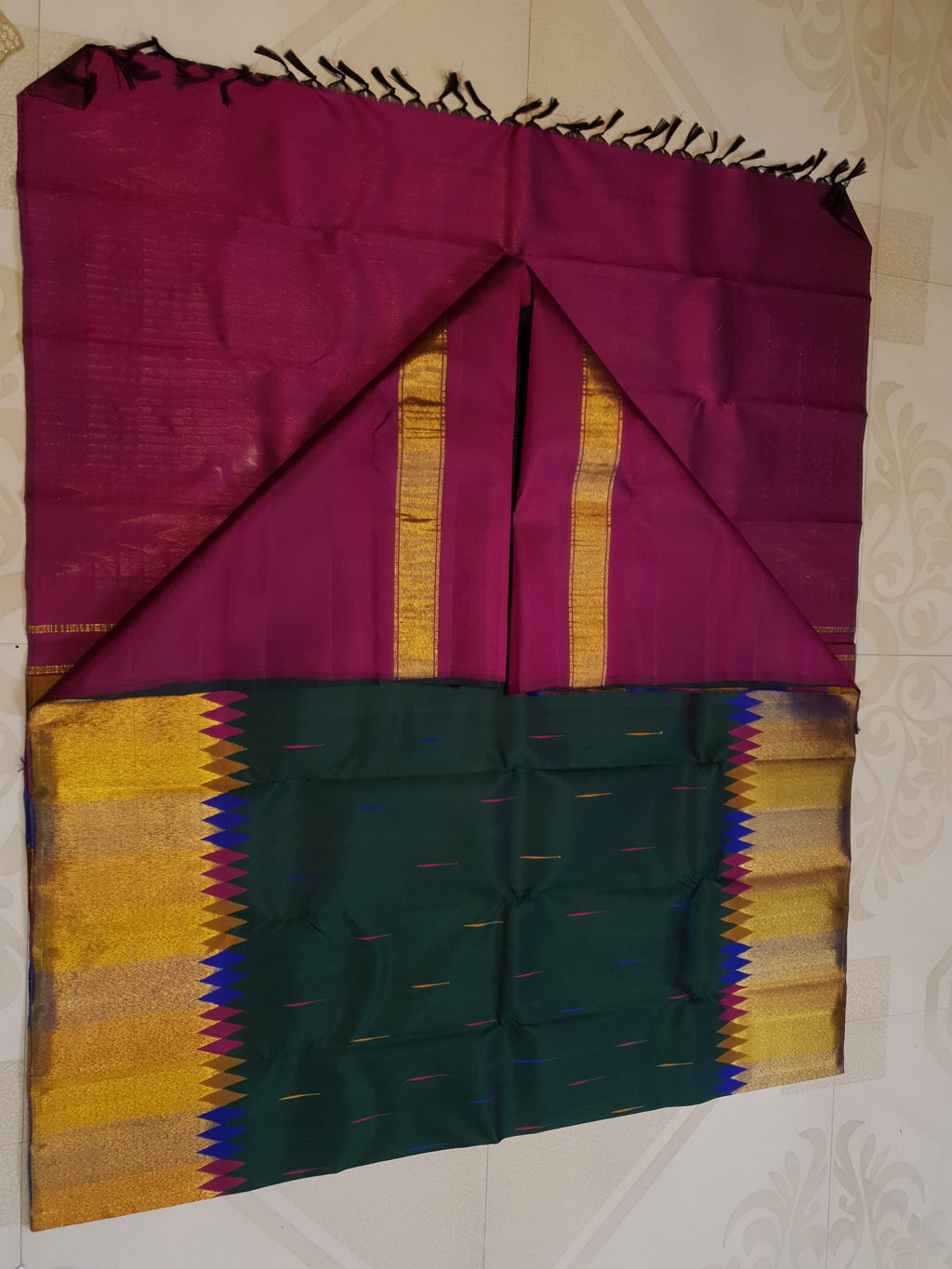 Bottle green Kanchipuram handloom 2G silk saree with 8-color temple border, traditional gold zari, and vibrant purple accents, perfect for weddings and festive occasions.