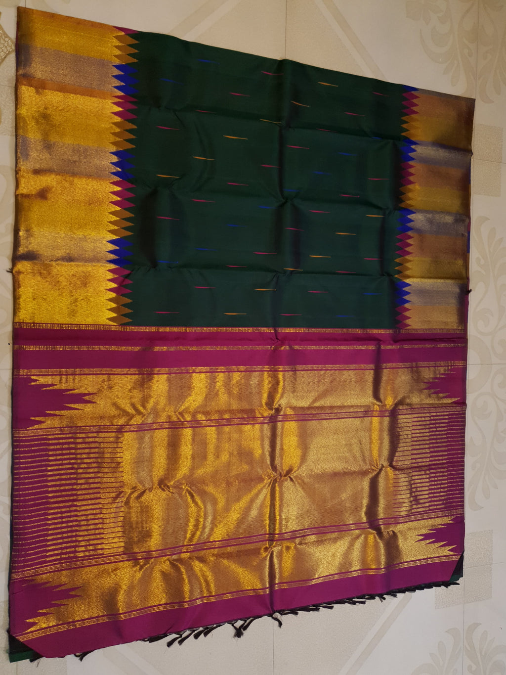 Bottle green Kanchipuram handloom 2G silk saree with 8-color temple border, traditional gold zari, and vibrant purple accents, perfect for weddings and festive occasions.
