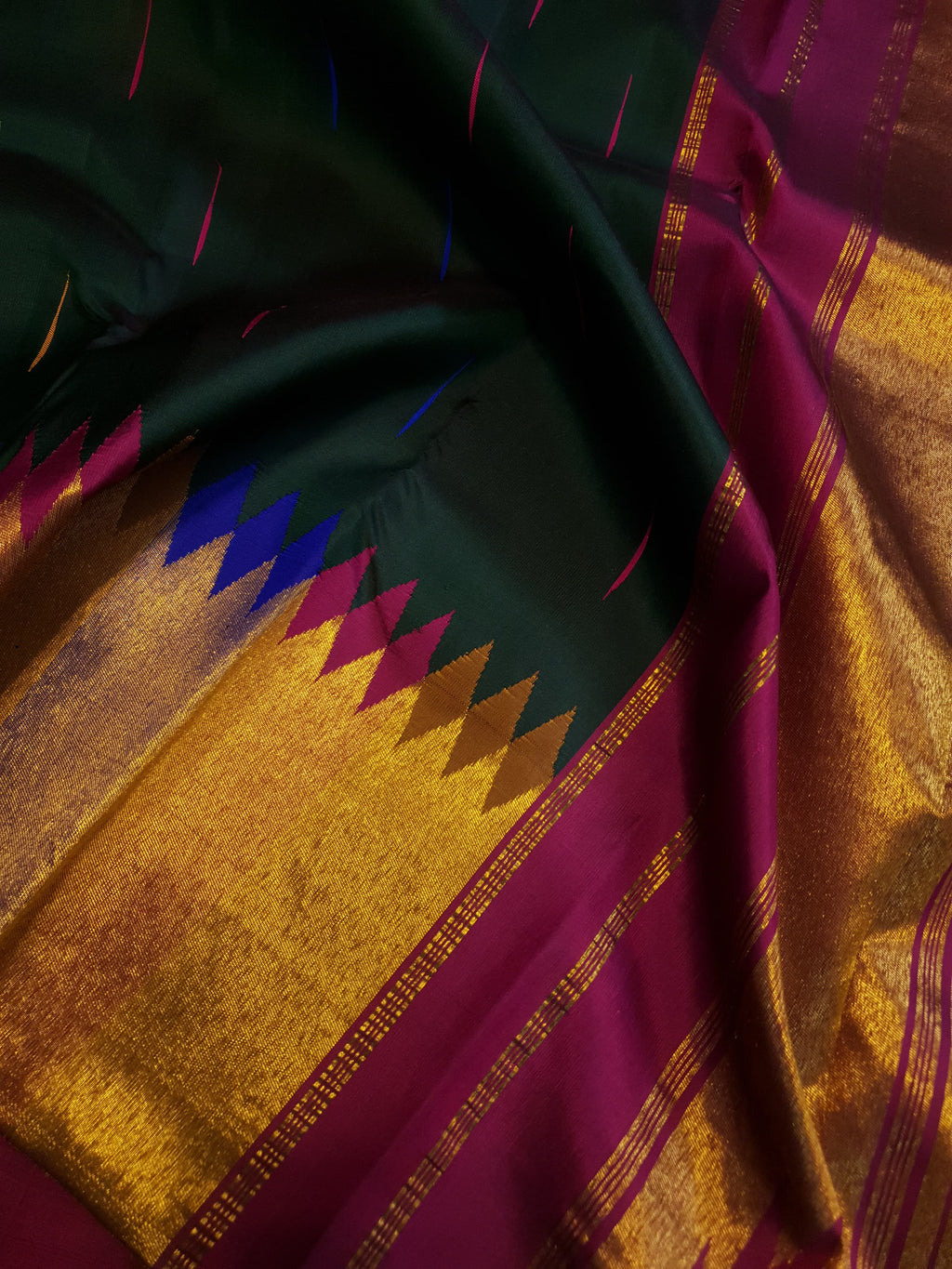 Bottle green Kanchipuram handloom 2G silk saree with 8-color temple border, traditional gold zari, and vibrant purple accents, perfect for weddings and festive occasions.