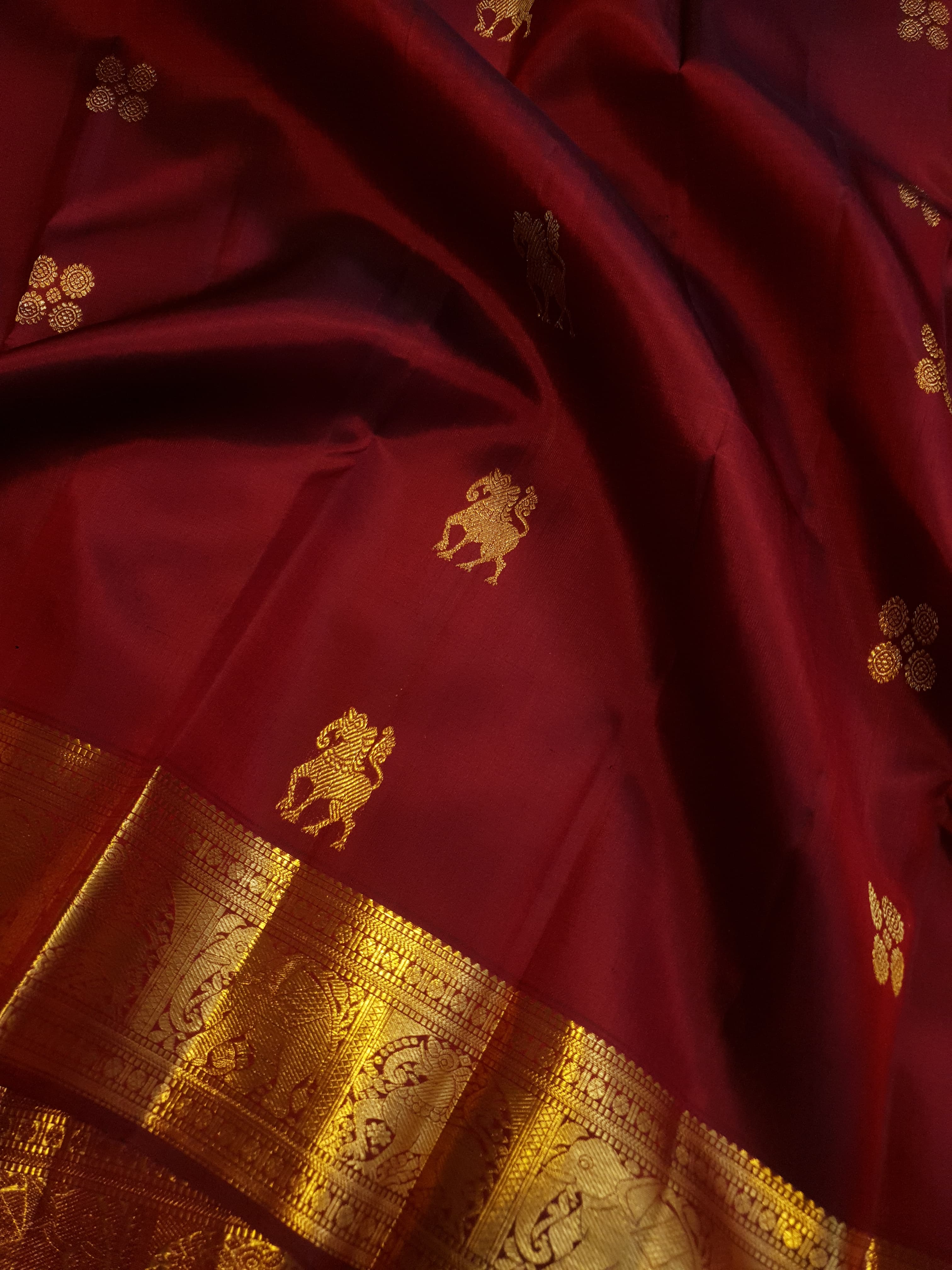 Maroon Kanchipuram handloom 2G gold bridal silk saree featuring traditional elephant zari borders and intricate woven buttas.