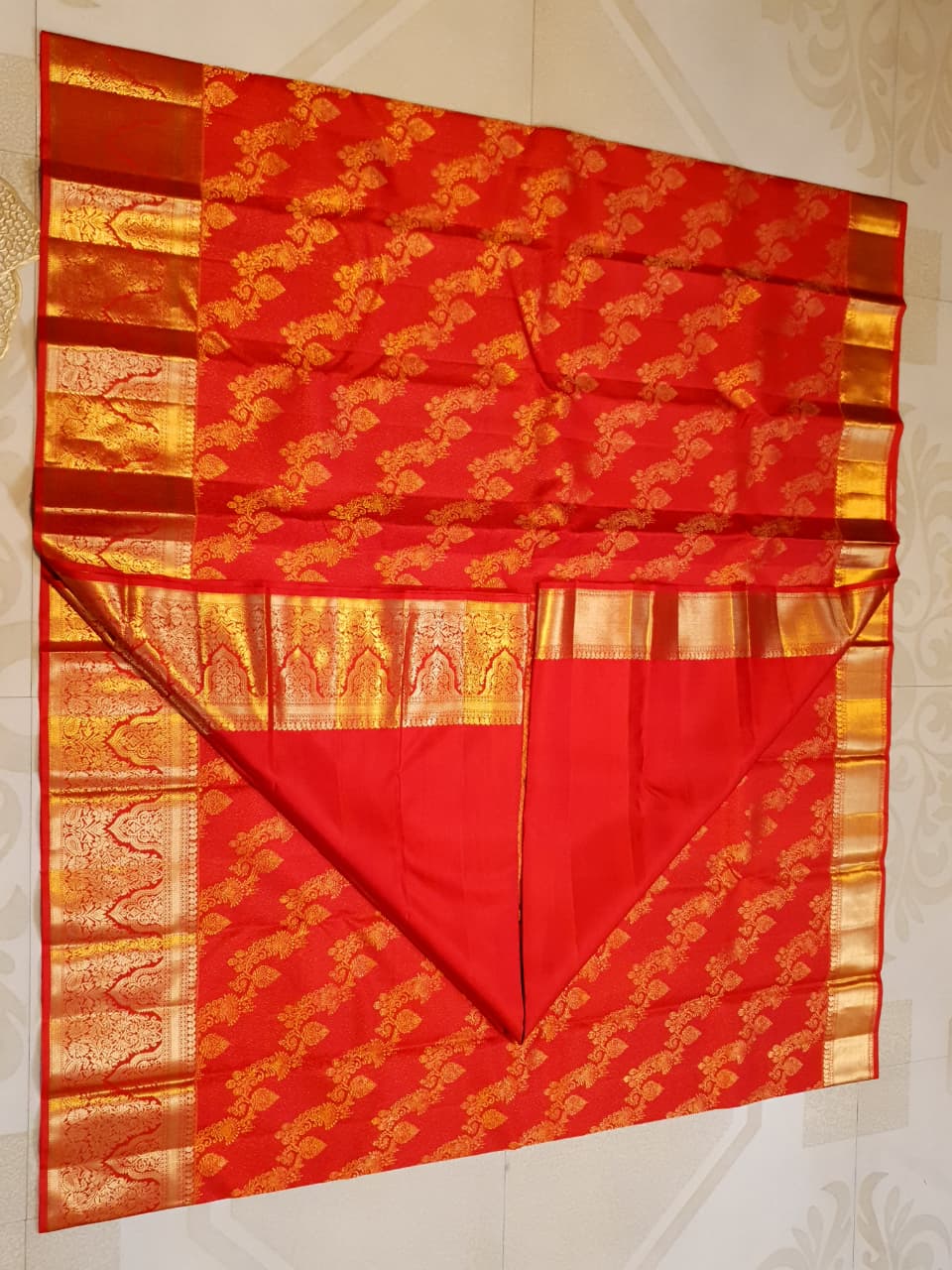 Exquisite Chilly Red Kanchipuram handloom silk saree with intricate gold zari detailing, styled for a traditional wedding look.