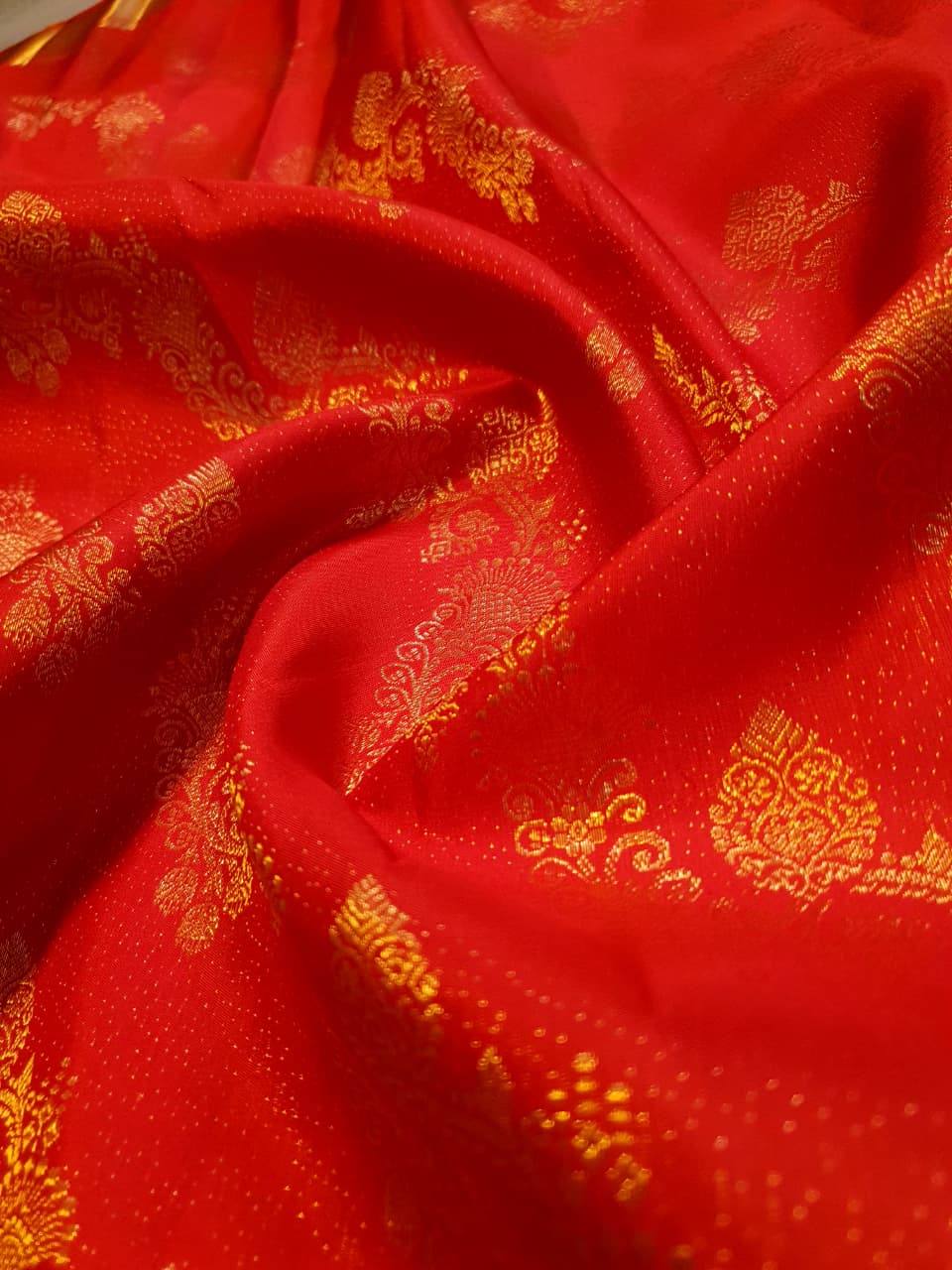 Exquisite Chilly Red Kanchipuram handloom silk saree with intricate gold zari detailing, styled for a traditional wedding look.