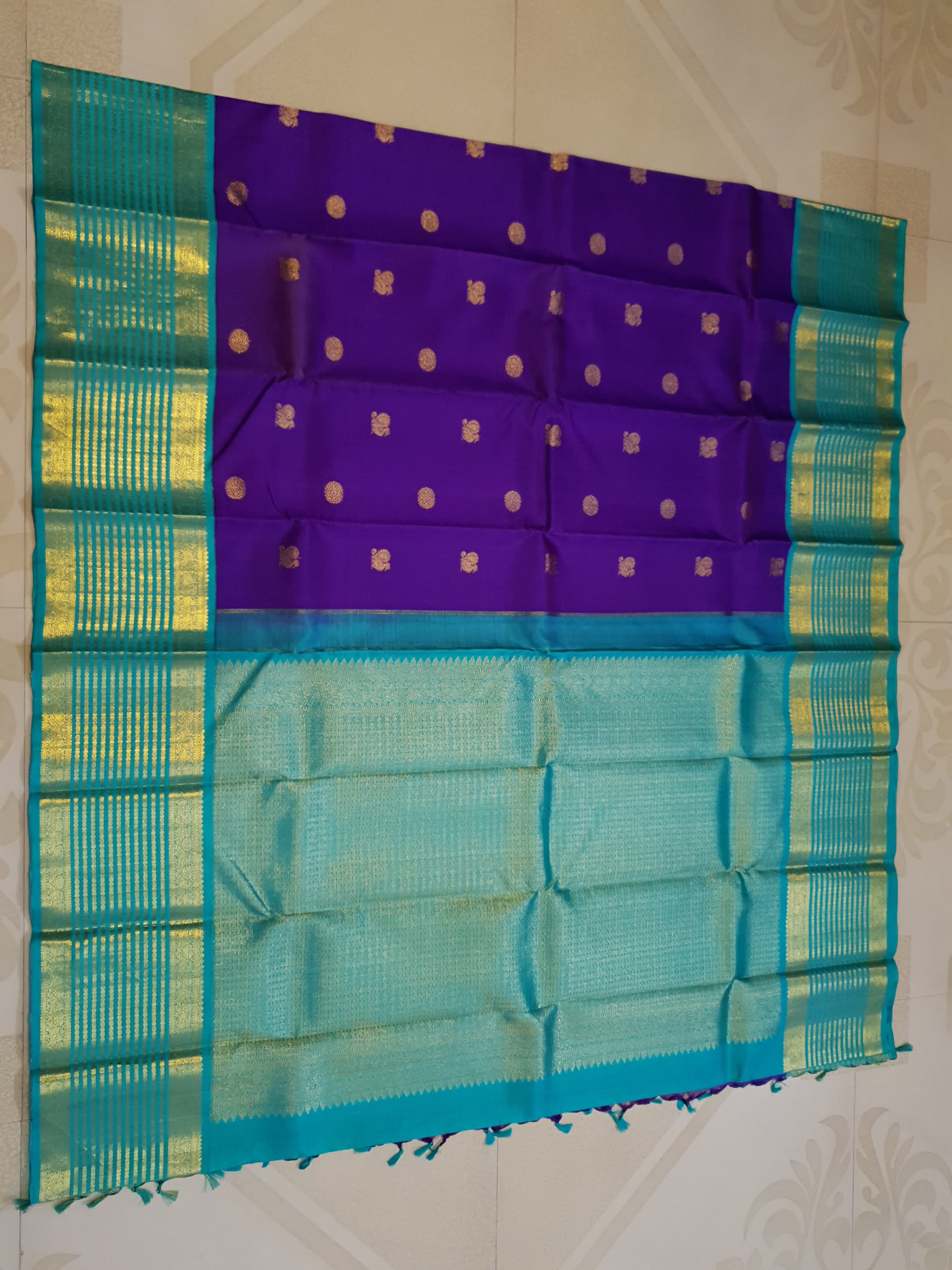 Purple Kanchipuram handloom 2G gold Korvai pattu silk saree showcasing a contrasting teal blue border with gold zari stripes.