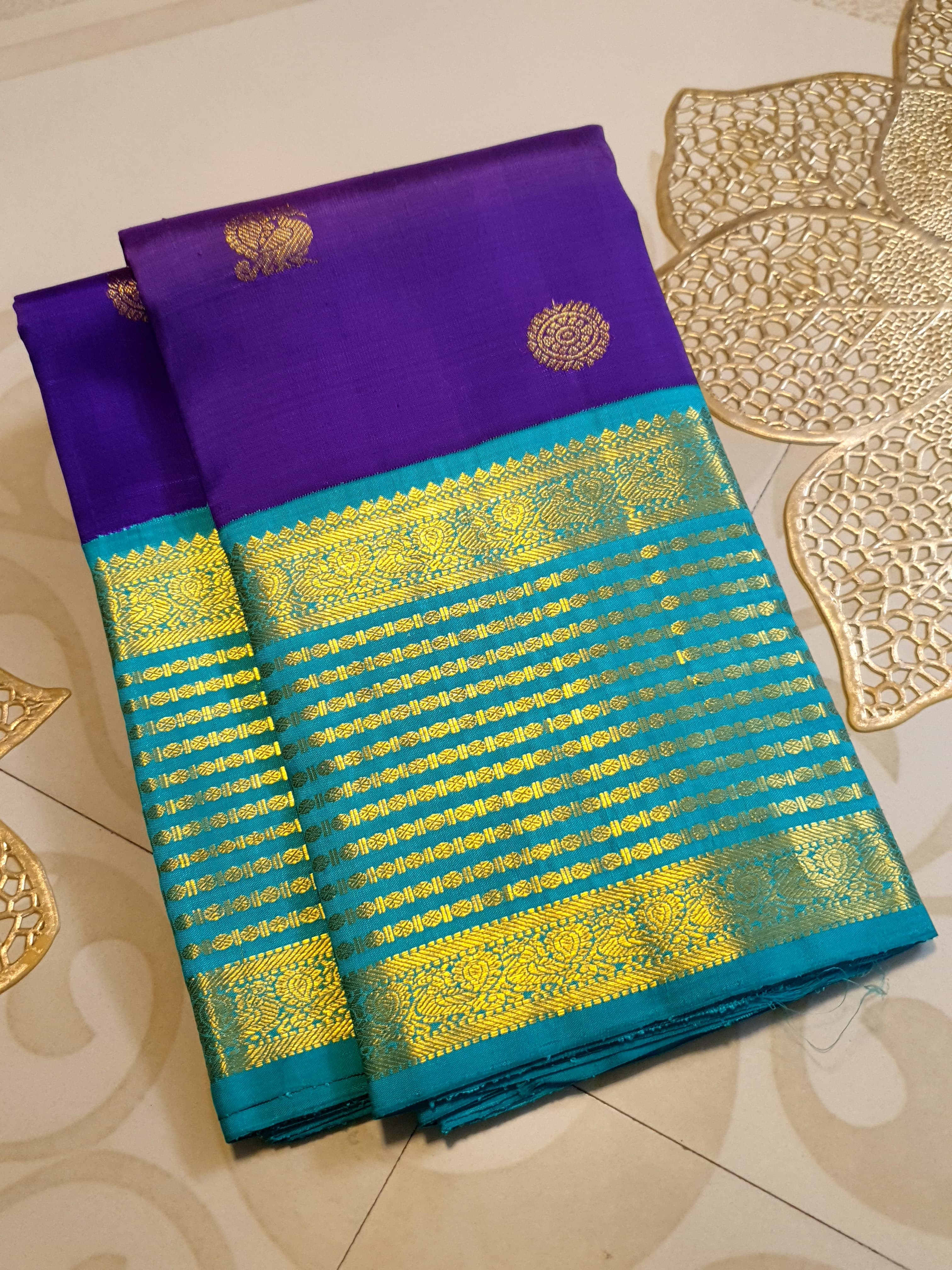 Purple Kanchipuram handloom 2G gold Korvai pattu silk saree showcasing a contrasting teal blue border with gold zari stripes.