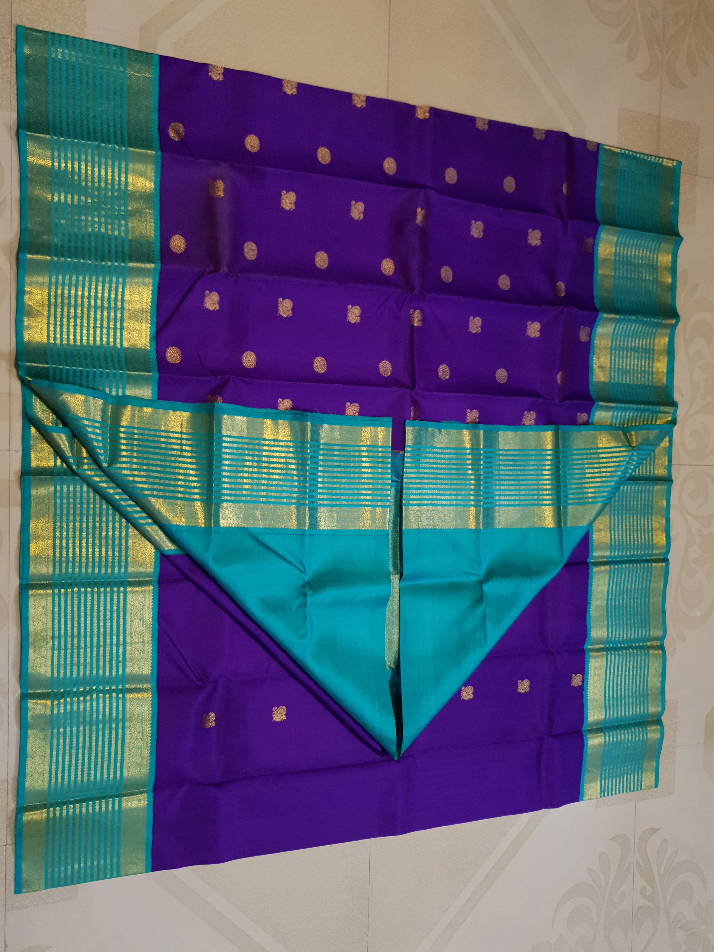 Purple Kanchipuram handloom 2G gold Korvai pattu silk saree showcasing a contrasting teal blue border with gold zari stripes.