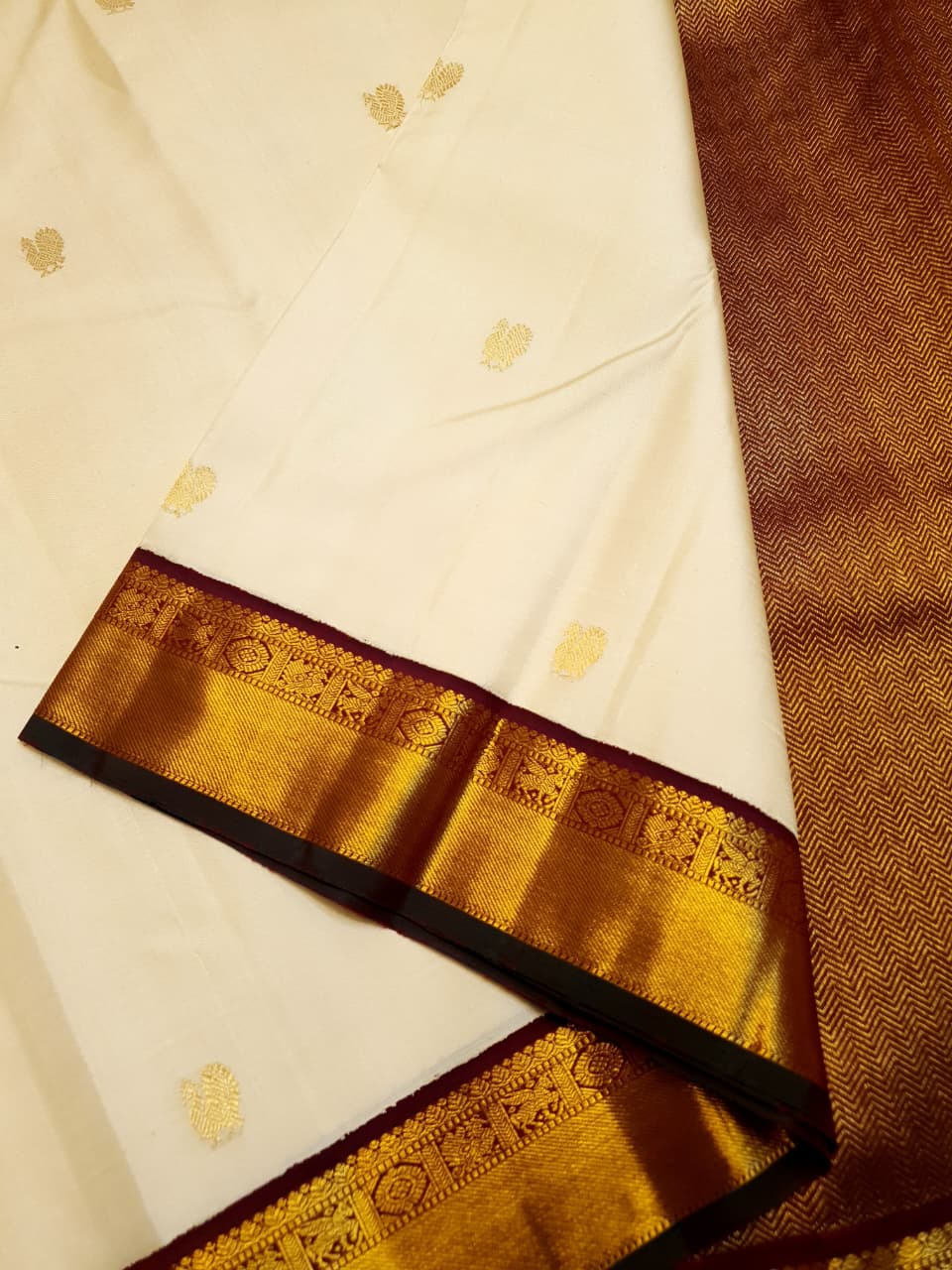 Cream Kanchipuram handloom Korvai Pattu silk saree featuring small 2G gold zari motifs, a rich contrast maroon pallu and border, and Silk Mark certification.