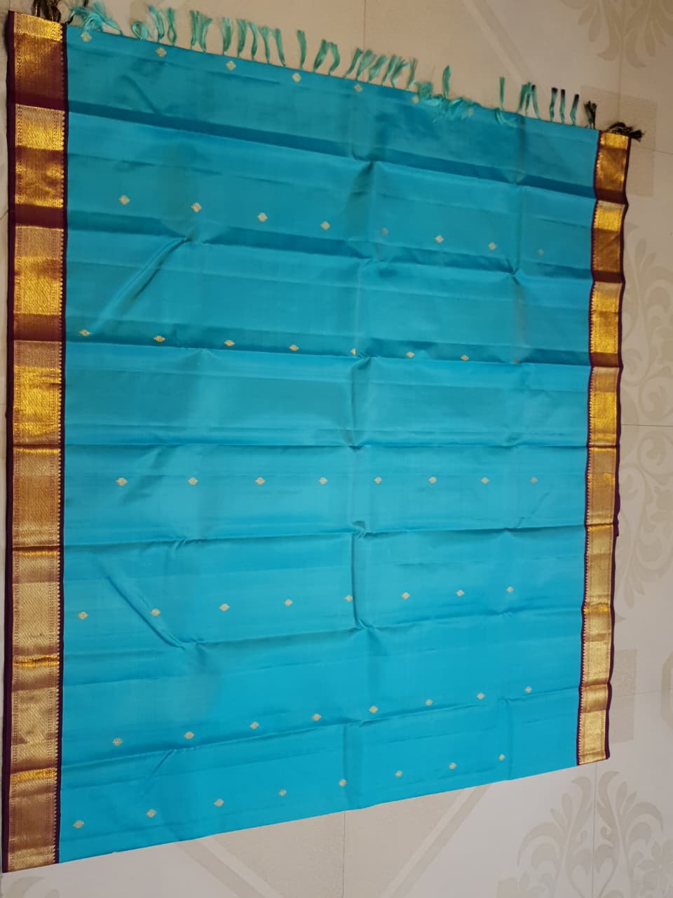 Vibrant turquoise blue Kanchipuram handloom silk saree with a contrasting deep purple korvai border and intricate gold zari work.
