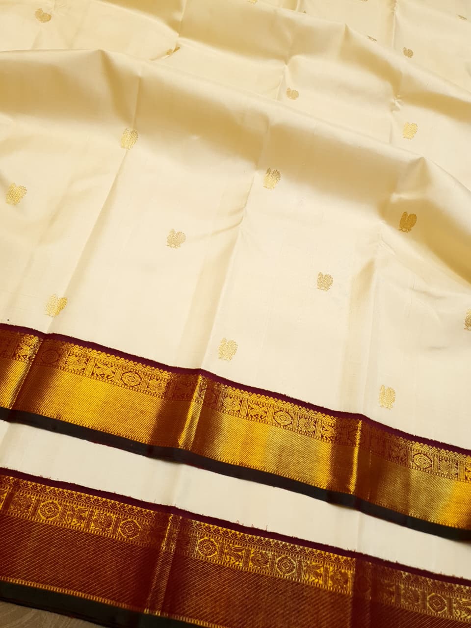 Cream Kanchipuram handloom Korvai Pattu silk saree featuring small 2G gold zari motifs, a rich contrast maroon pallu and border, and Silk Mark certification.