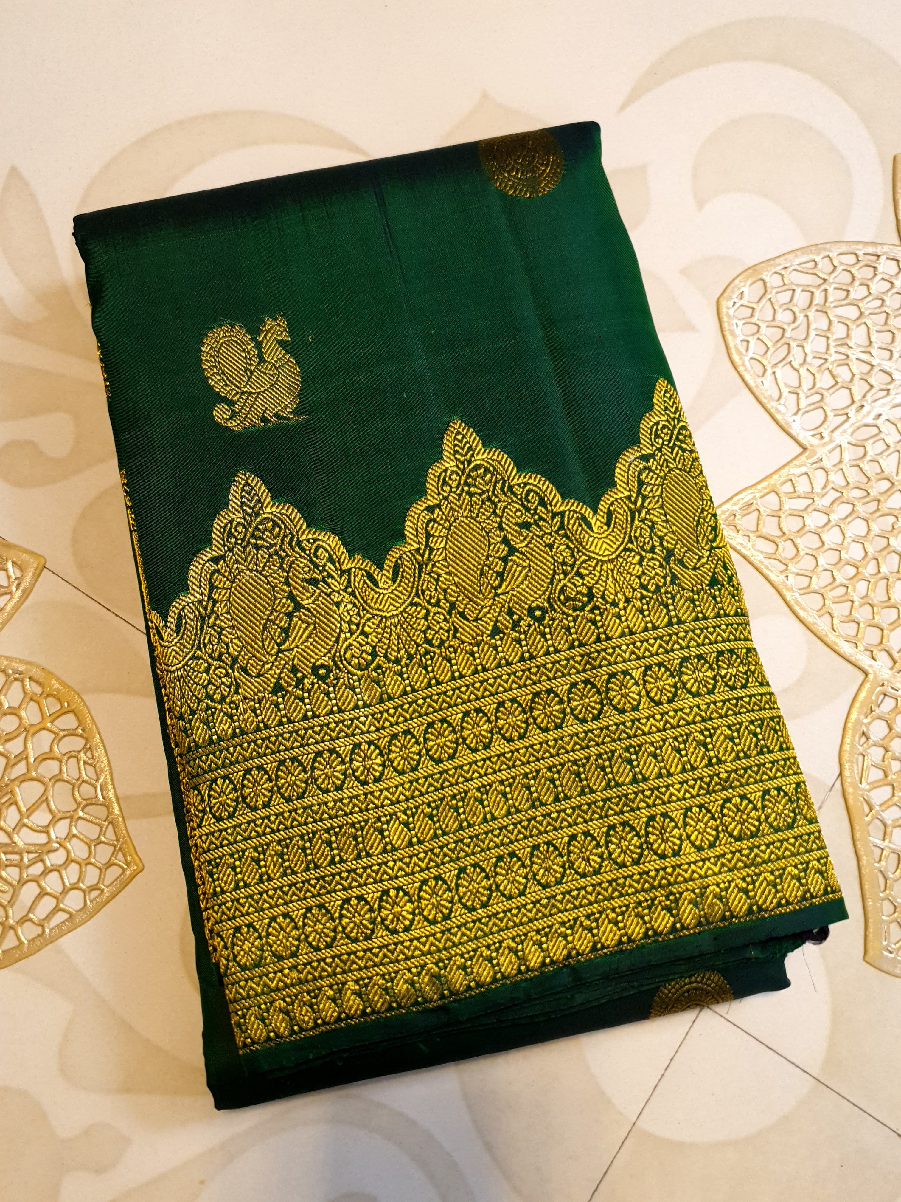 Bottle Green Kanchipuram handloom pattu silk saree featuring 2G gold zari motifs, a rich traditional border, and Silk Mark certification.