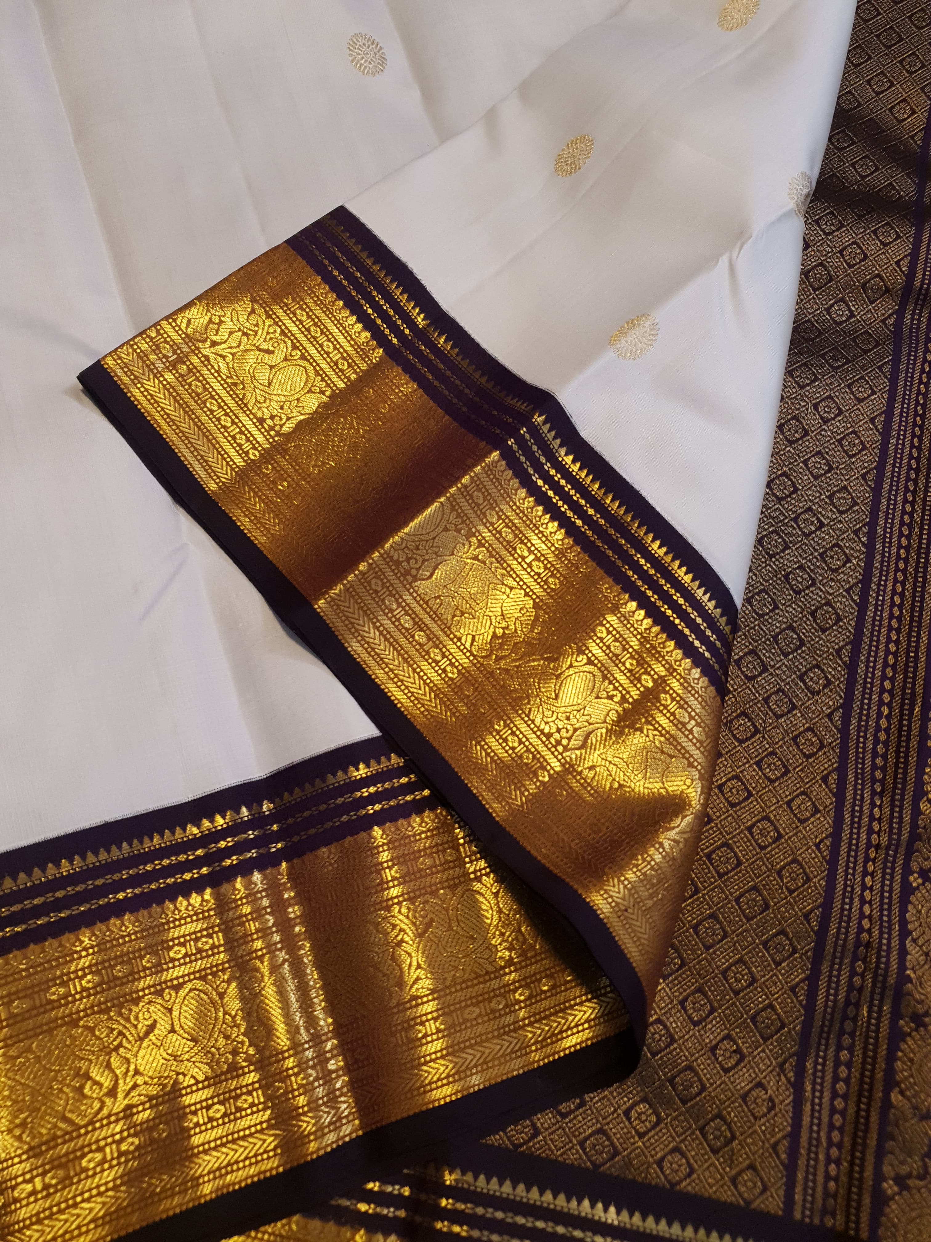 Cream Kanchipuram handloom 2G gold korvai silk saree showcasing a rich dark border and intricate gold zari motifs.