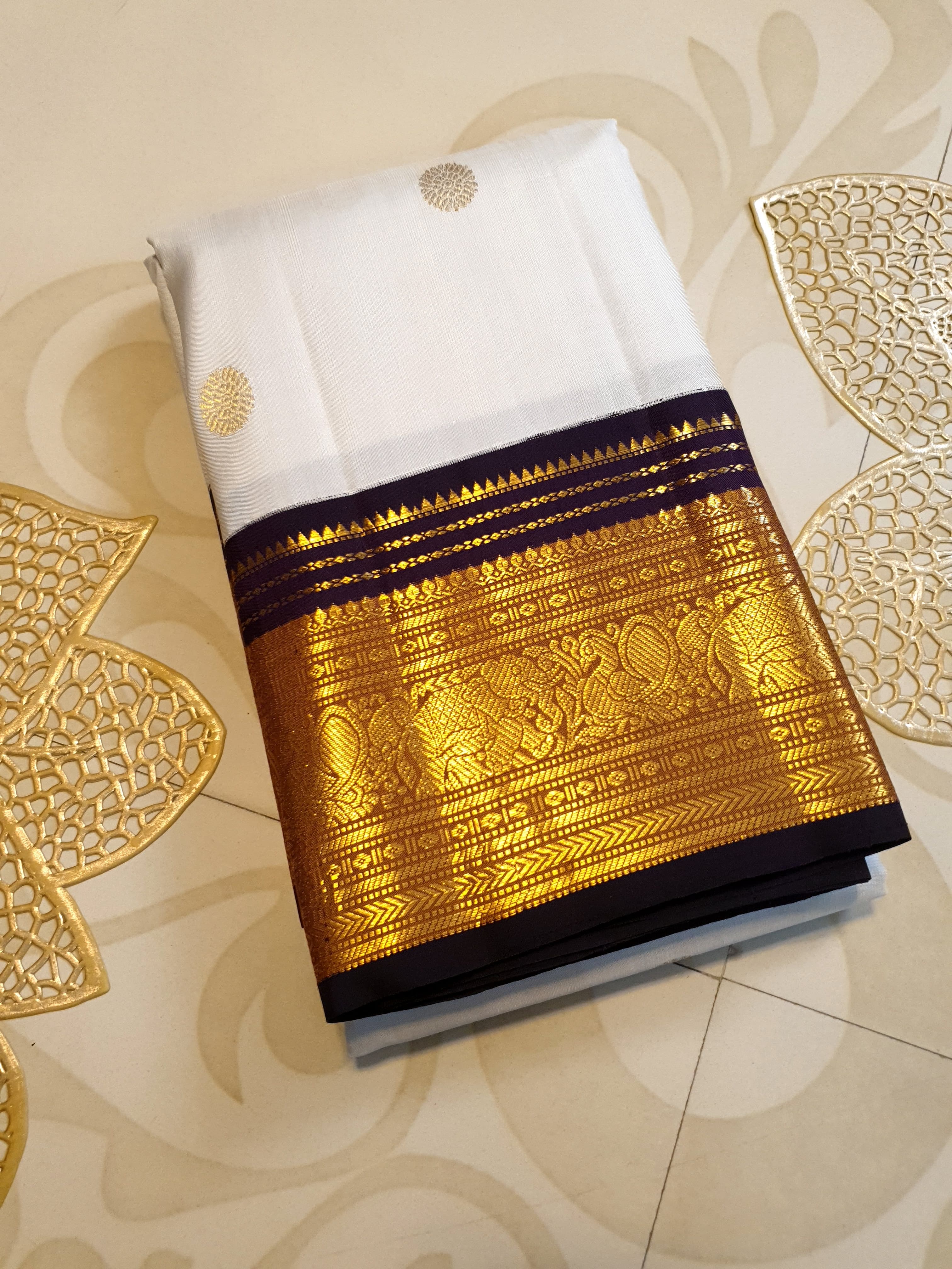 Cream Kanchipuram handloom 2G gold korvai silk saree showcasing a rich dark border and intricate gold zari motifs.