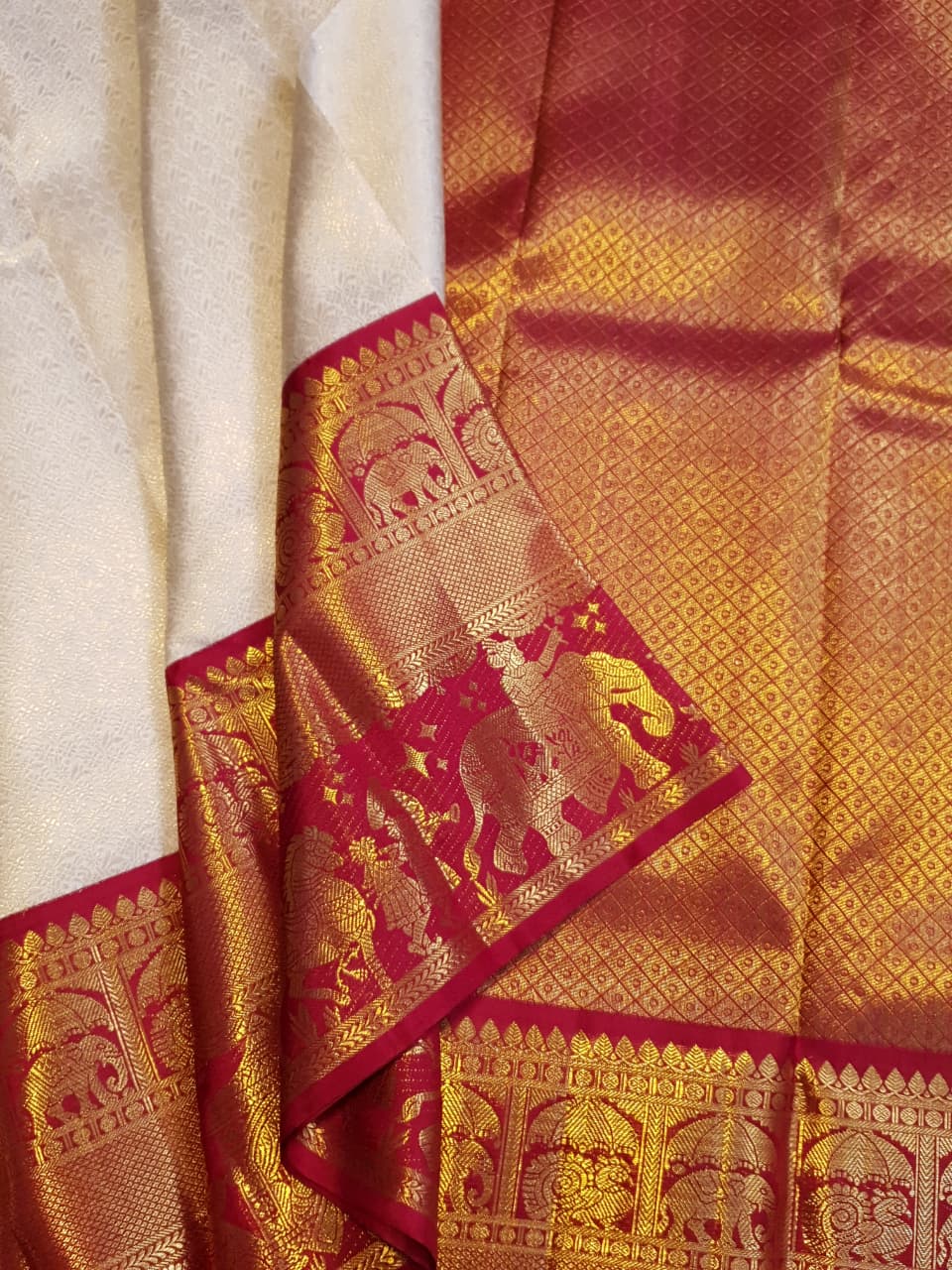 Cream Kanchipuram handloom silk saree with a vibrant pink and gold border, featuring intricate Kalyana Pallakku zari work, accessorized with traditional gold jewelry.