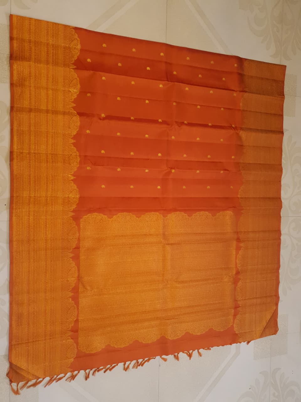 Burnt Orange Kanchipuram handloom pattu silk bridal saree featuring small gold buttas, intricate gold zari scalloped borders, and a certified silk mark weave.