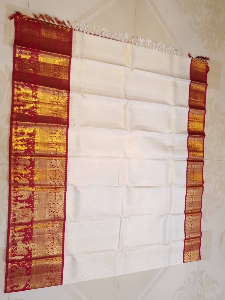 Cream Kanchipuram handloom silk saree with a vibrant pink and gold border, featuring intricate Kalyana Pallakku zari work, accessorized with traditional gold jewelry.