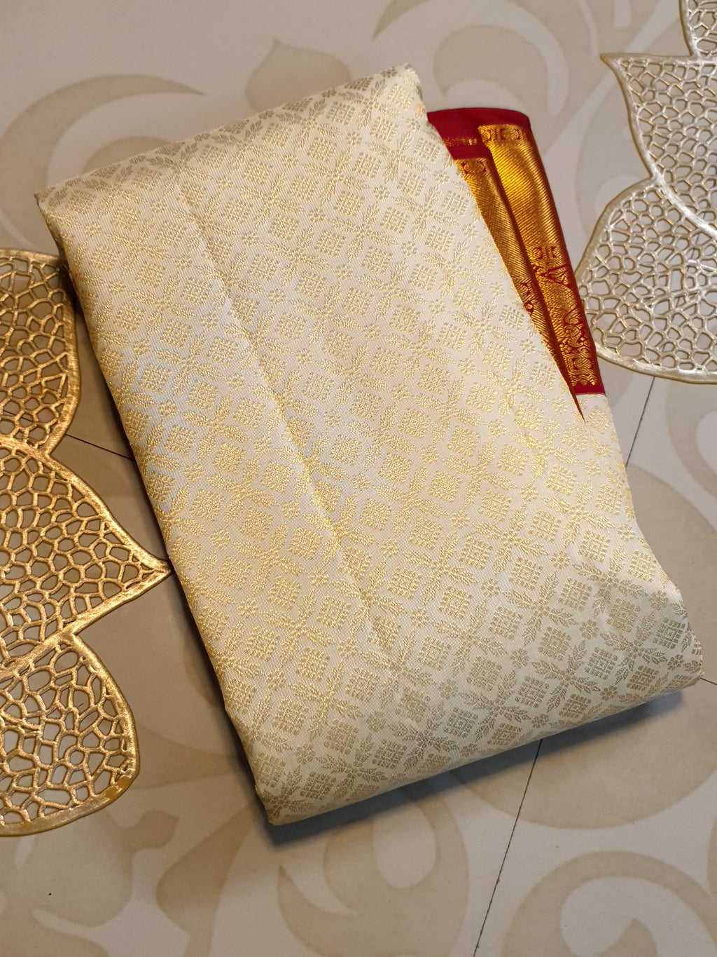 Off-white Kanchipuram handloom pattu silk bridal saree with a rich red and gold zari border.