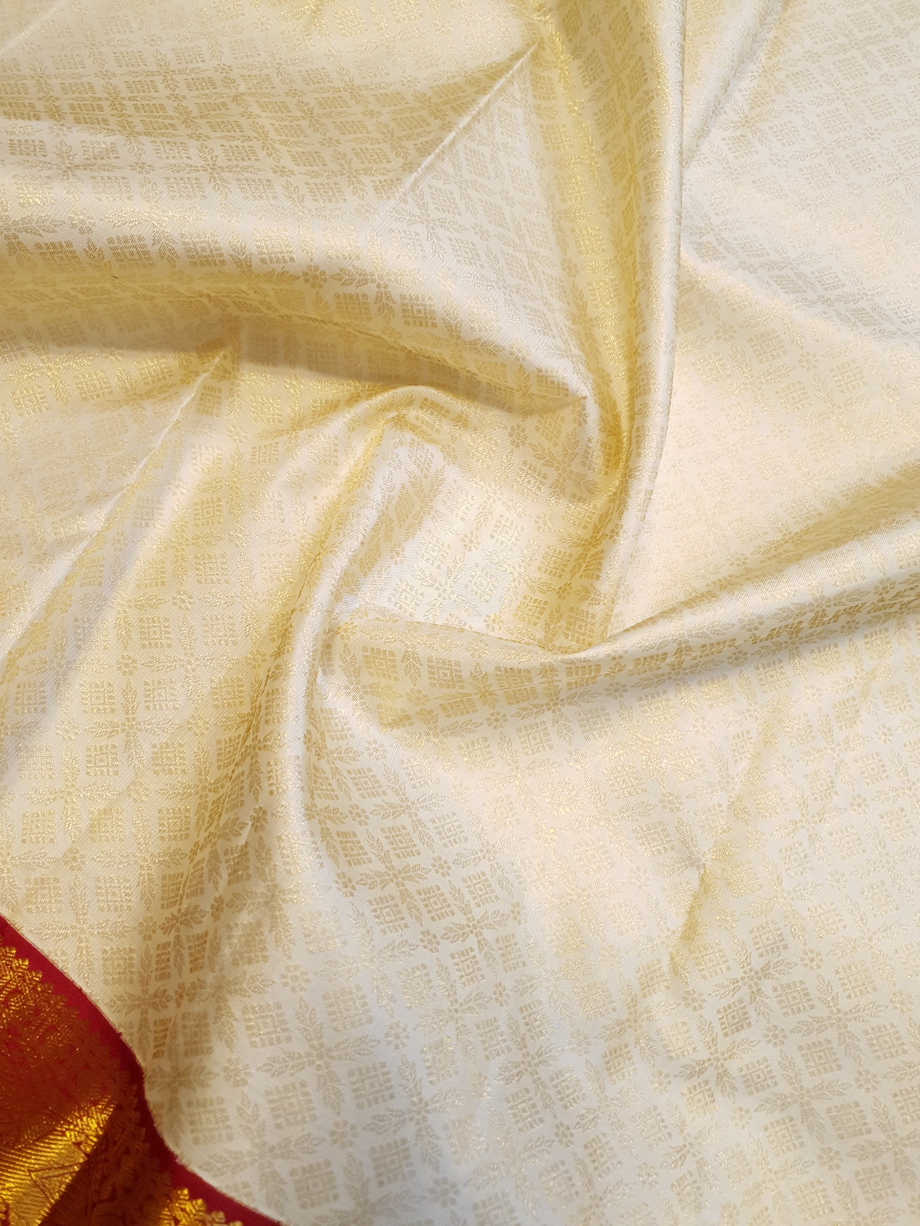 Off-white Kanchipuram handloom pattu silk bridal saree with a rich red and gold zari border.