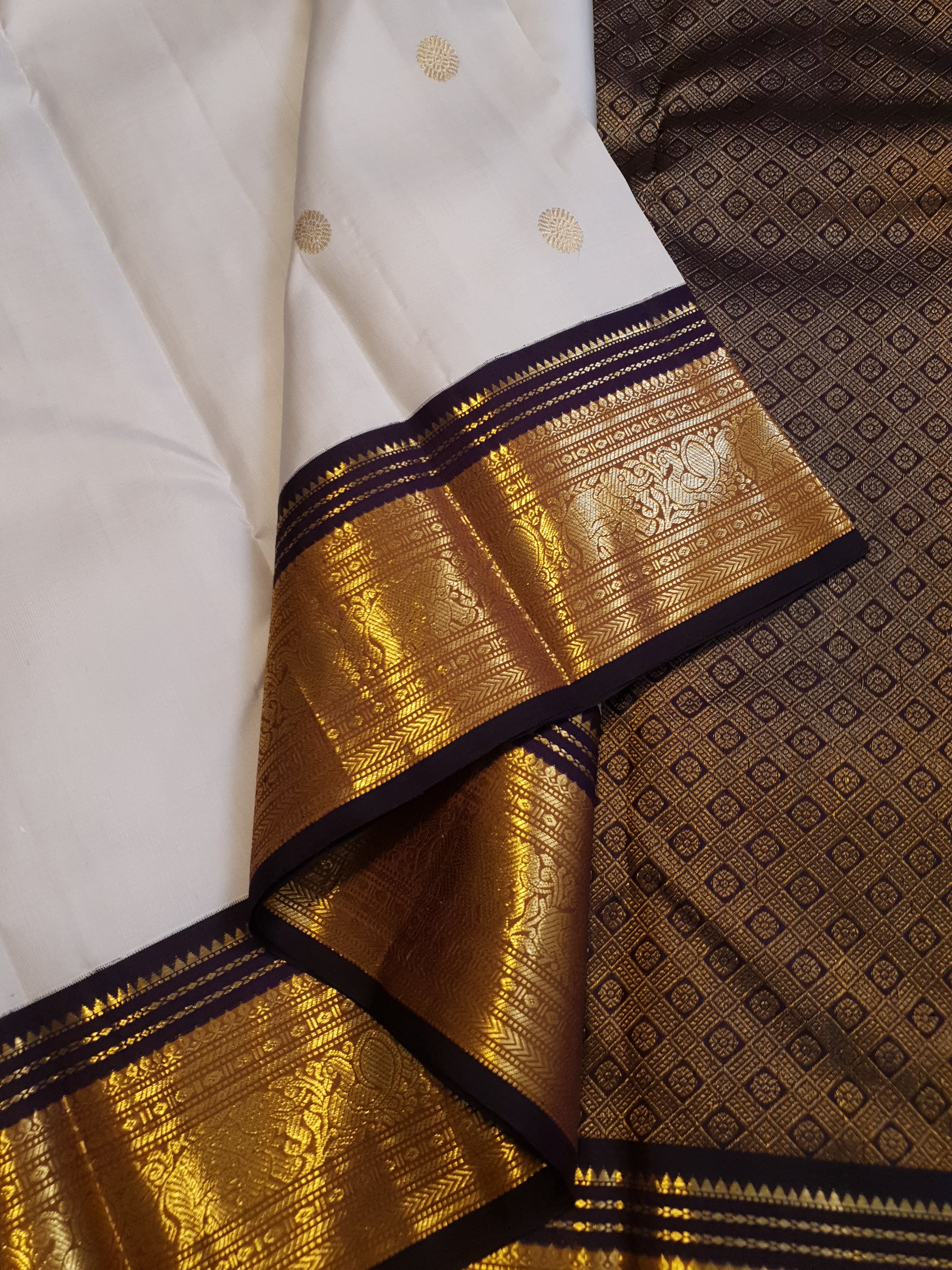 Cream Kanchipuram handloom 2G gold korvai silk saree showcasing a rich dark border and intricate gold zari motifs.