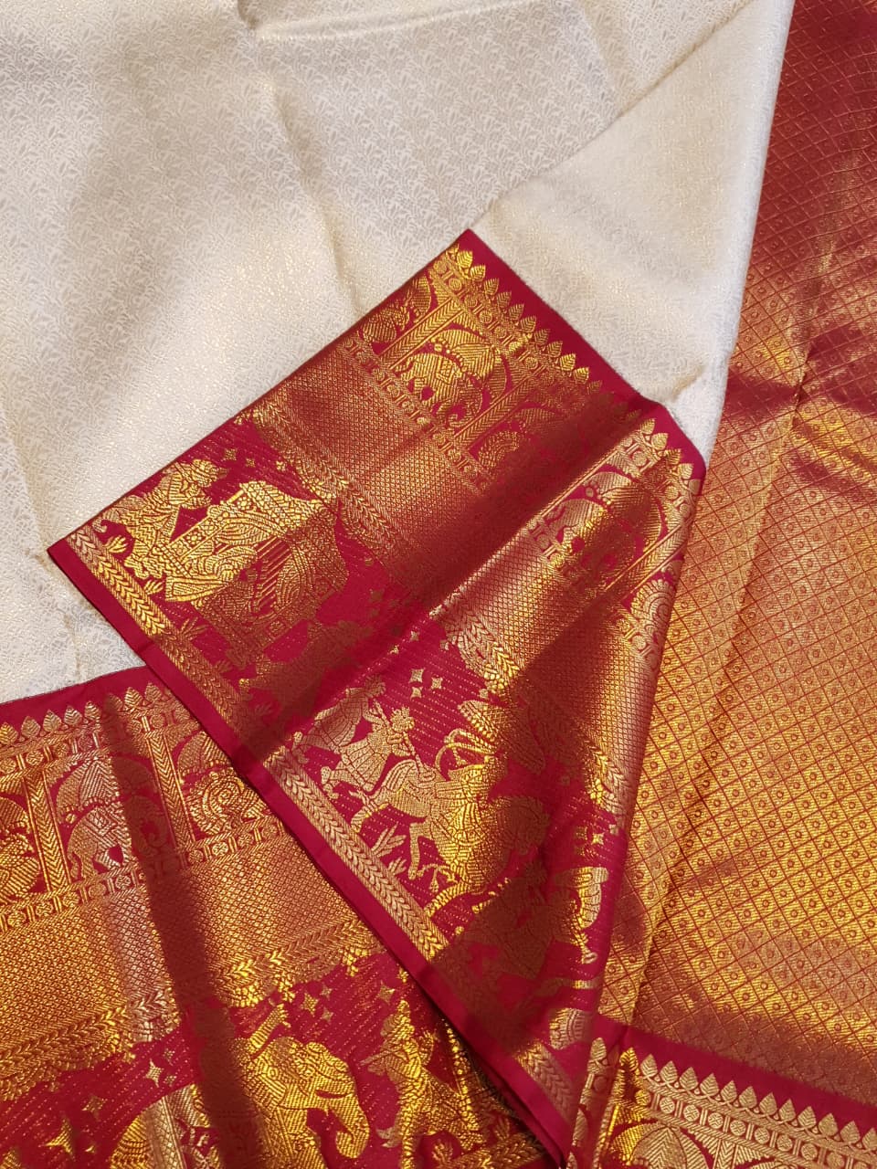 Cream Kanchipuram handloom silk saree with a vibrant pink and gold border, featuring intricate Kalyana Pallakku zari work, accessorized with traditional gold jewelry.