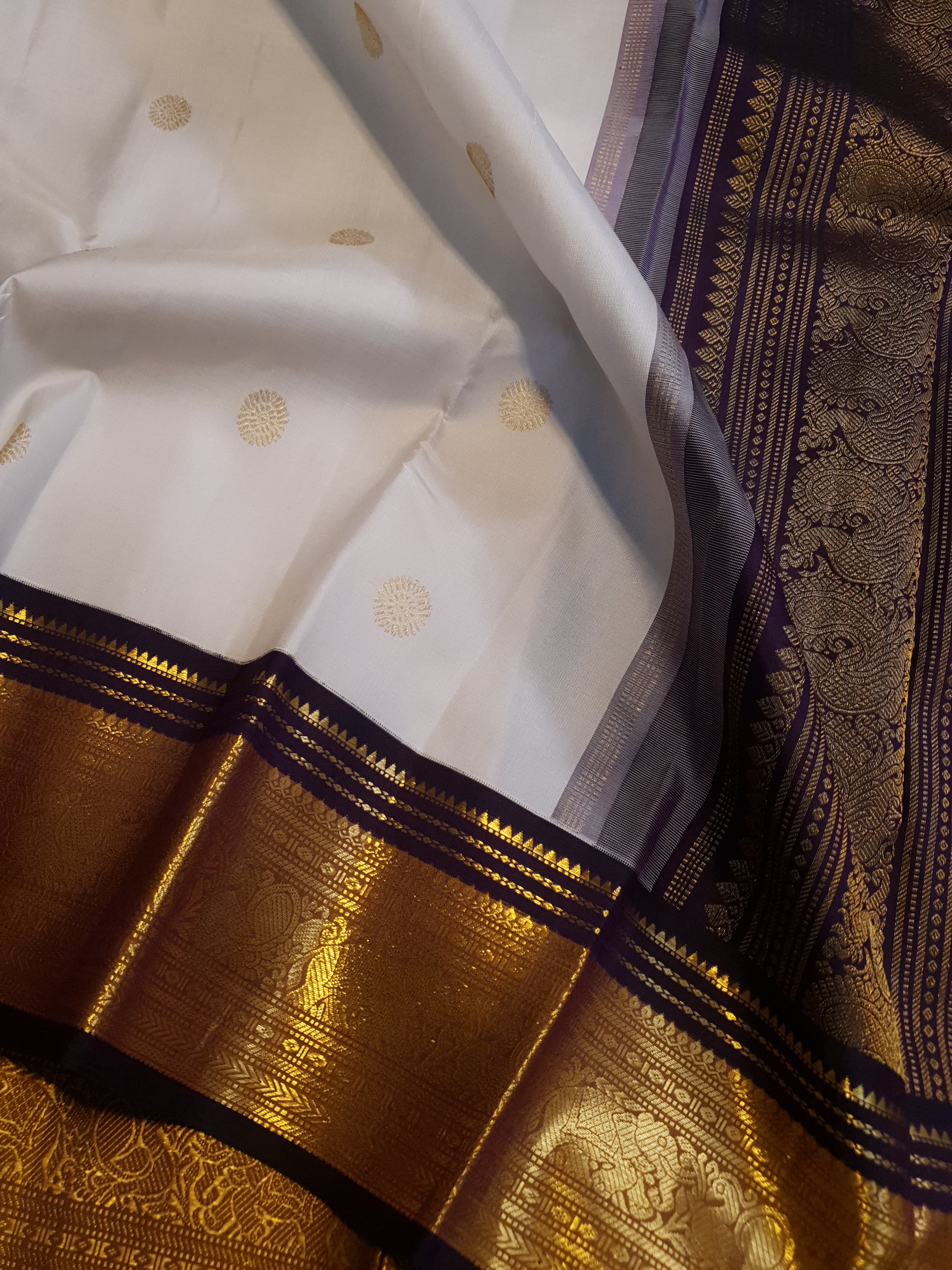 Cream Kanchipuram handloom 2G gold korvai silk saree showcasing a rich dark border and intricate gold zari motifs.