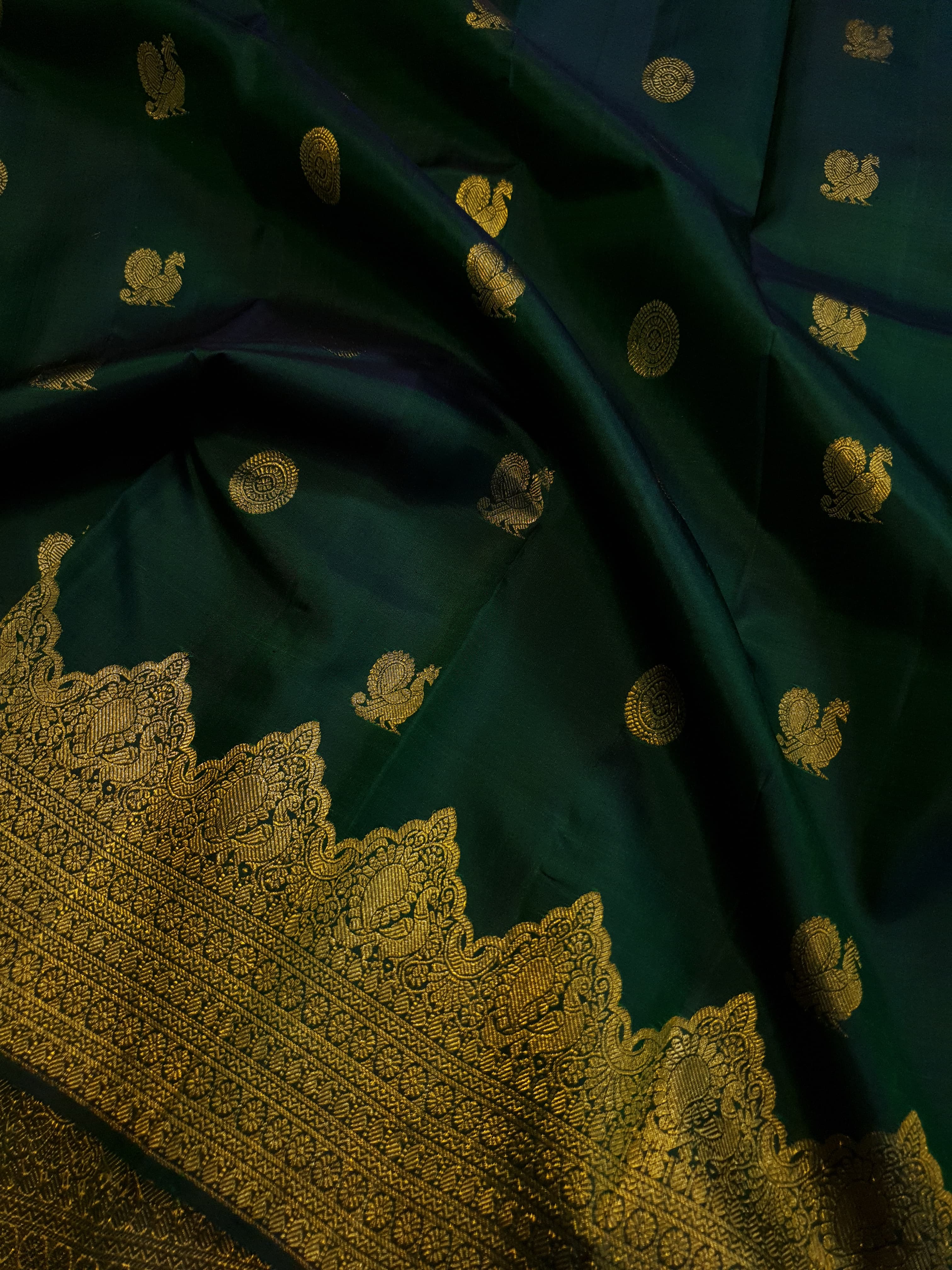 Bottle Green Kanchipuram handloom pattu silk saree featuring 2G gold zari motifs, a rich traditional border, and Silk Mark certification.