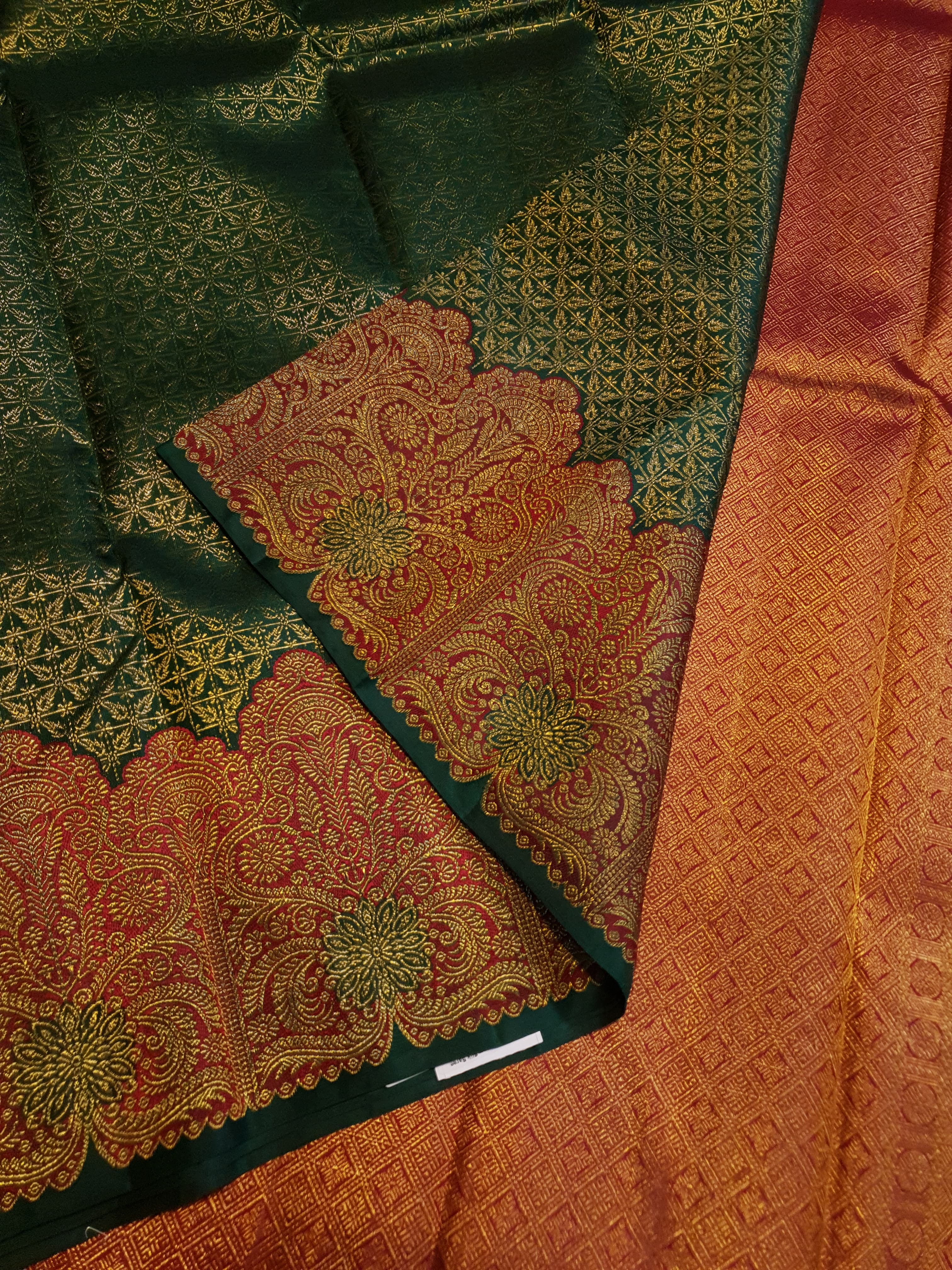 Bottle Green Kanchipuram handloom pattu silk saree featuring intricate 2G gold weave, a rich contrasting Red pallu, matching Red borders, and a certified silk mark weave.
