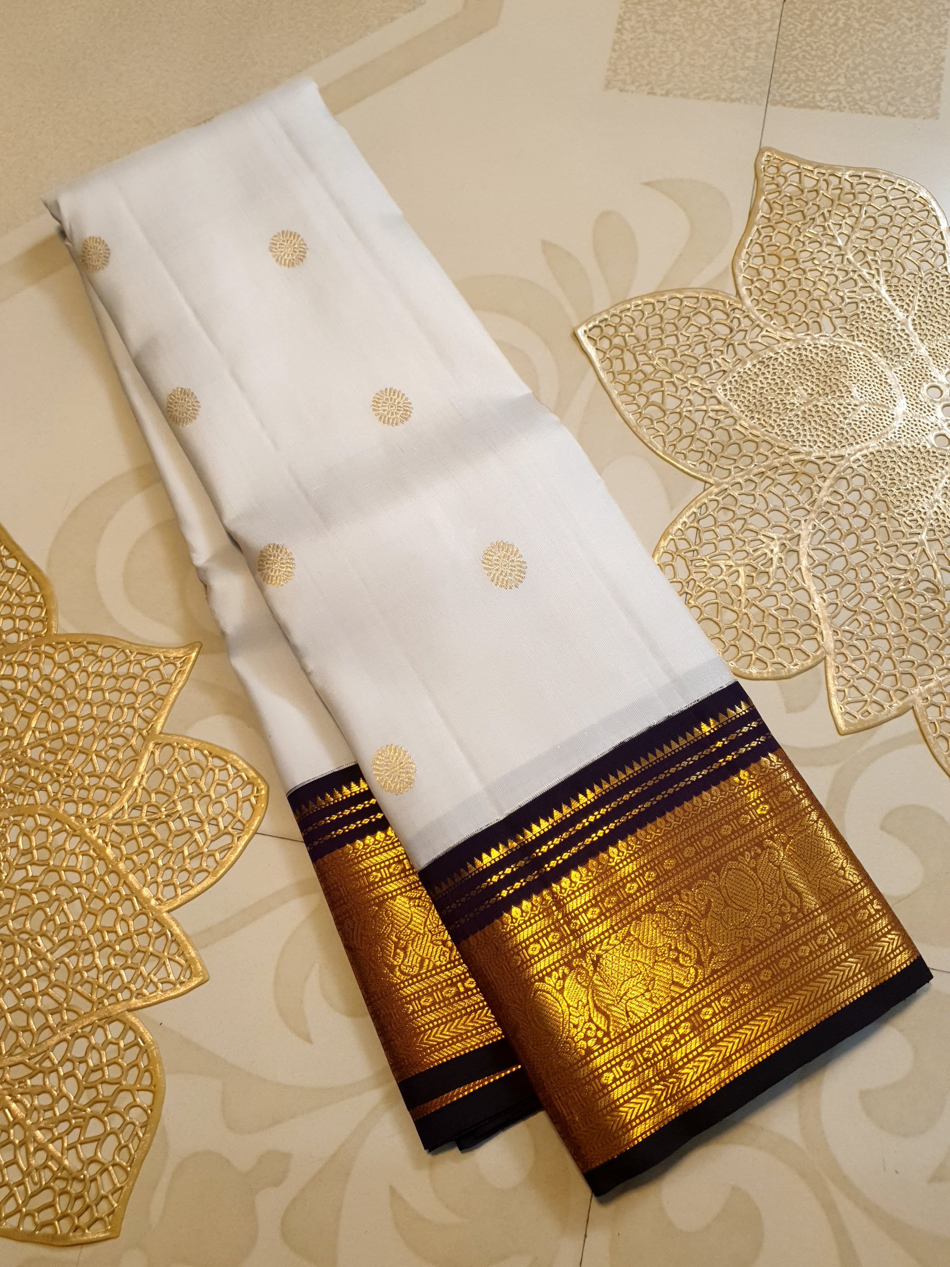 Cream Kanchipuram handloom 2G gold korvai silk saree showcasing a rich dark border and intricate gold zari motifs.