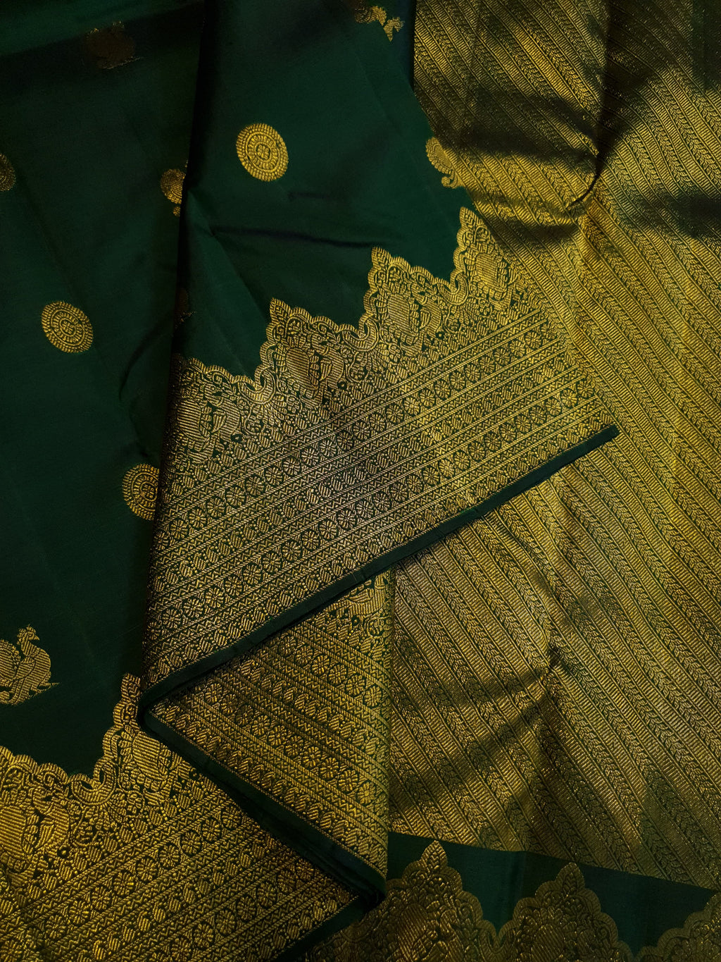 Bottle Green Kanchipuram handloom pattu silk saree featuring 2G gold zari motifs, a rich traditional border, and Silk Mark certification.