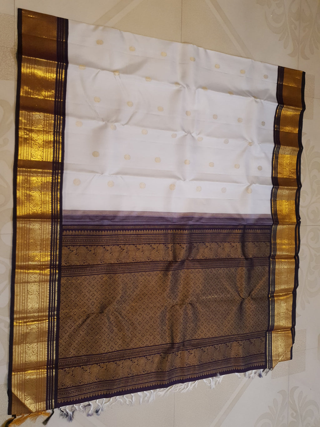 Cream Kanchipuram handloom 2G gold korvai silk saree showcasing a rich dark border and intricate gold zari motifs.
