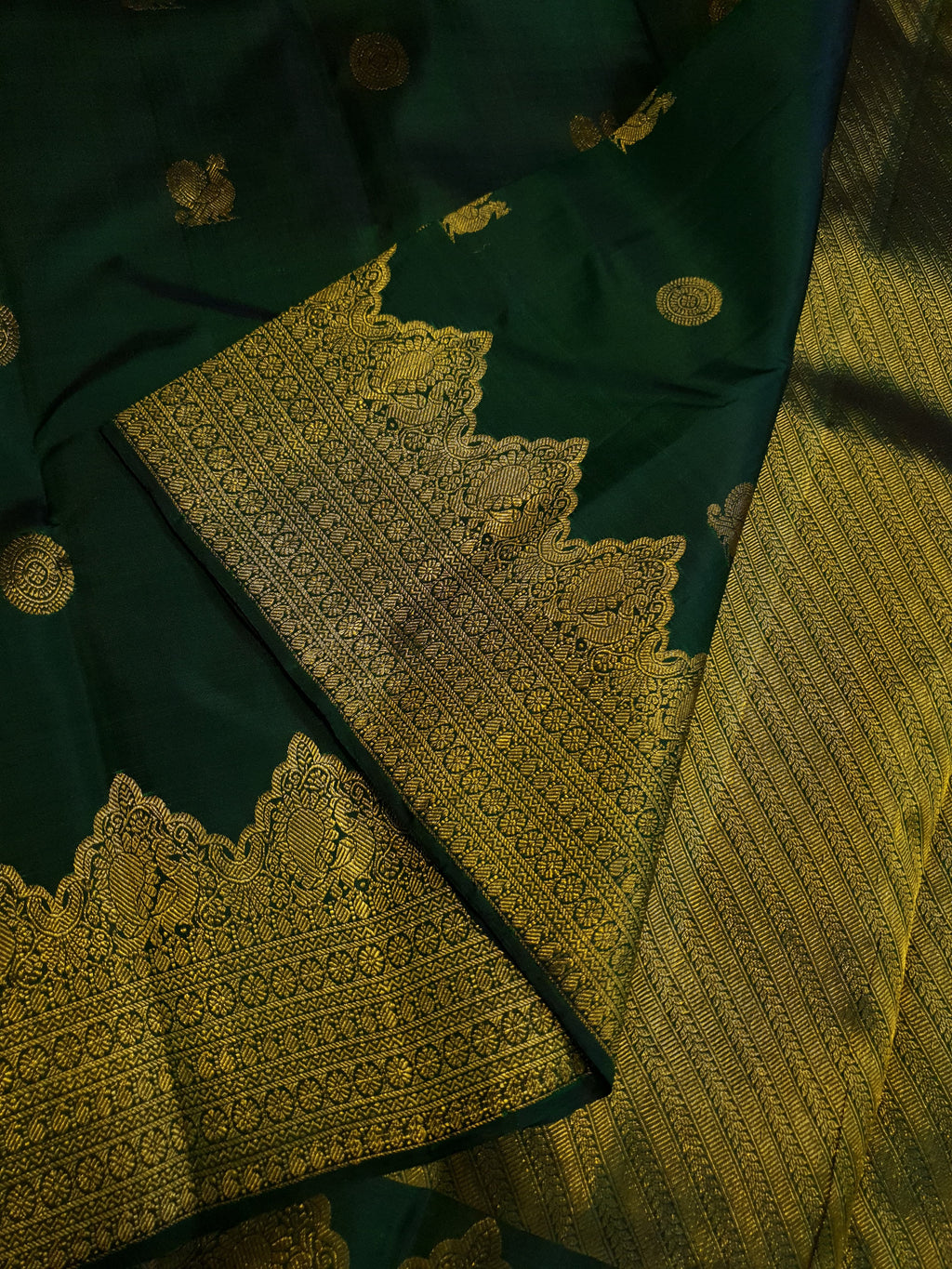 Bottle Green Kanchipuram handloom pattu silk saree featuring 2G gold zari motifs, a rich traditional border, and Silk Mark certification.