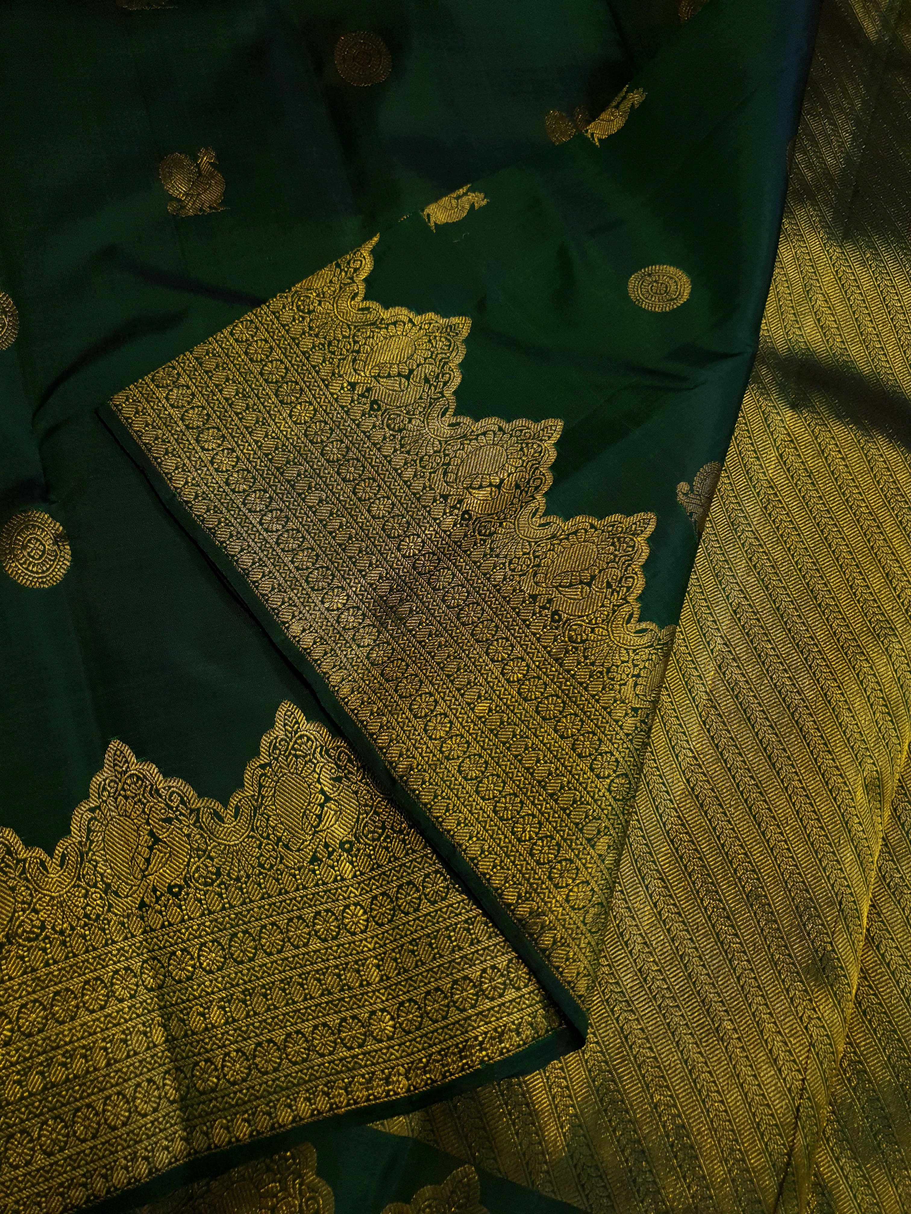 Bottle Green Kanchipuram handloom pattu silk saree featuring 2G gold zari motifs, a rich traditional border, and Silk Mark certification.